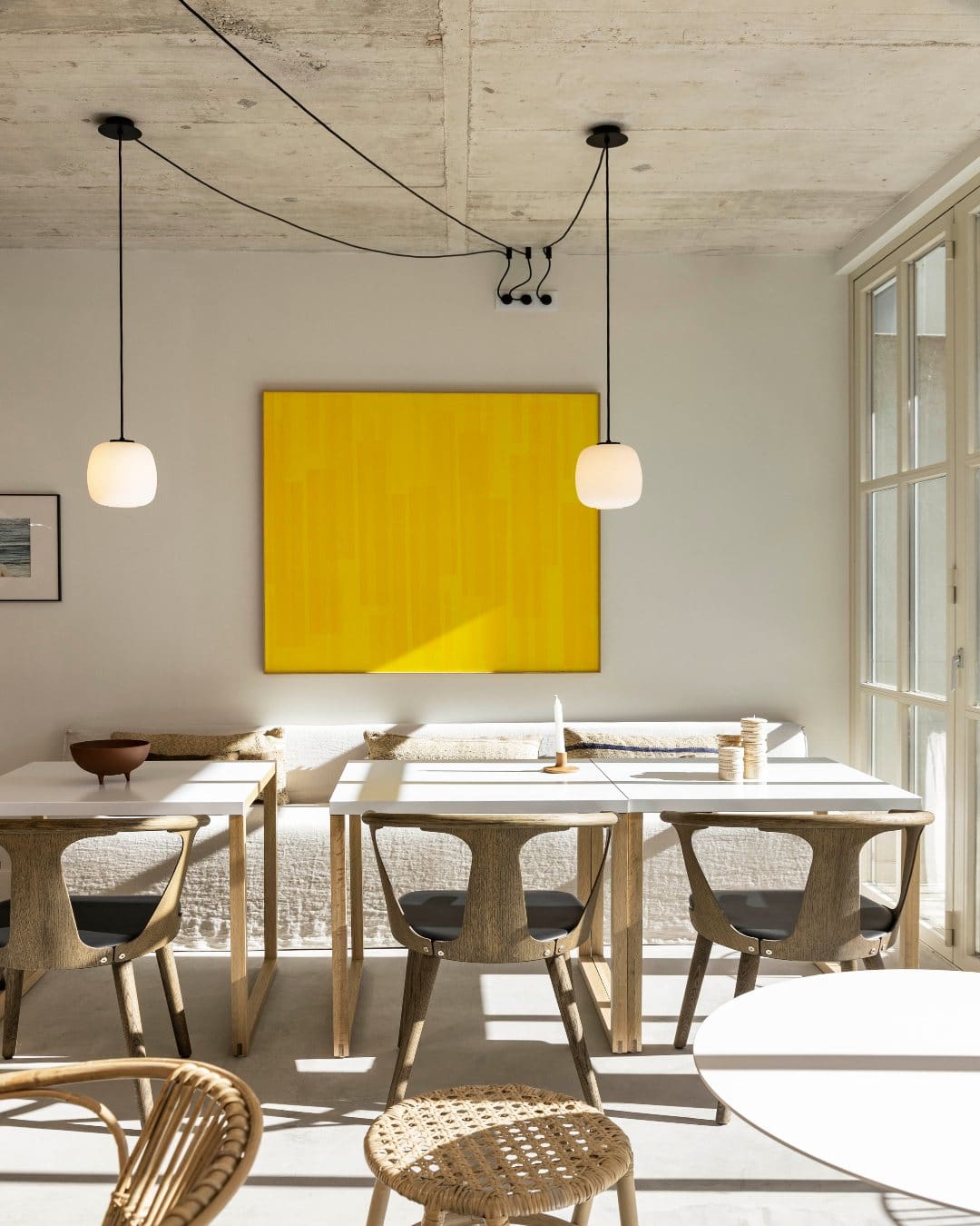 A light-filled kitchen area with vibrant artworks and pendant lights at Pátio do Tijolo