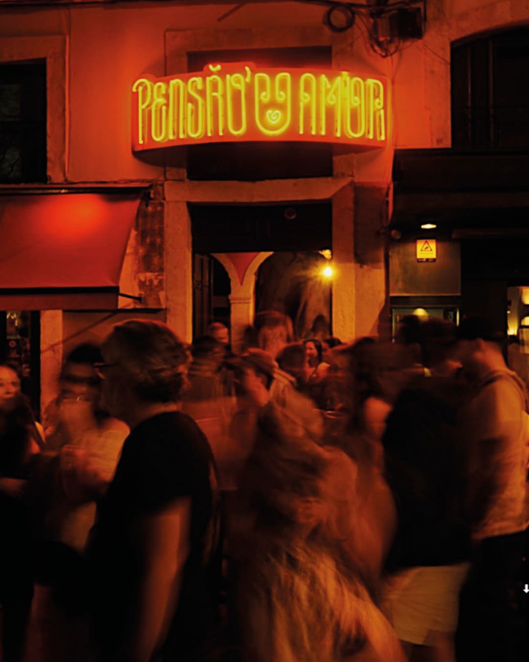 Crowds spill onto the street outside Pensão Amo bar in Lisbon