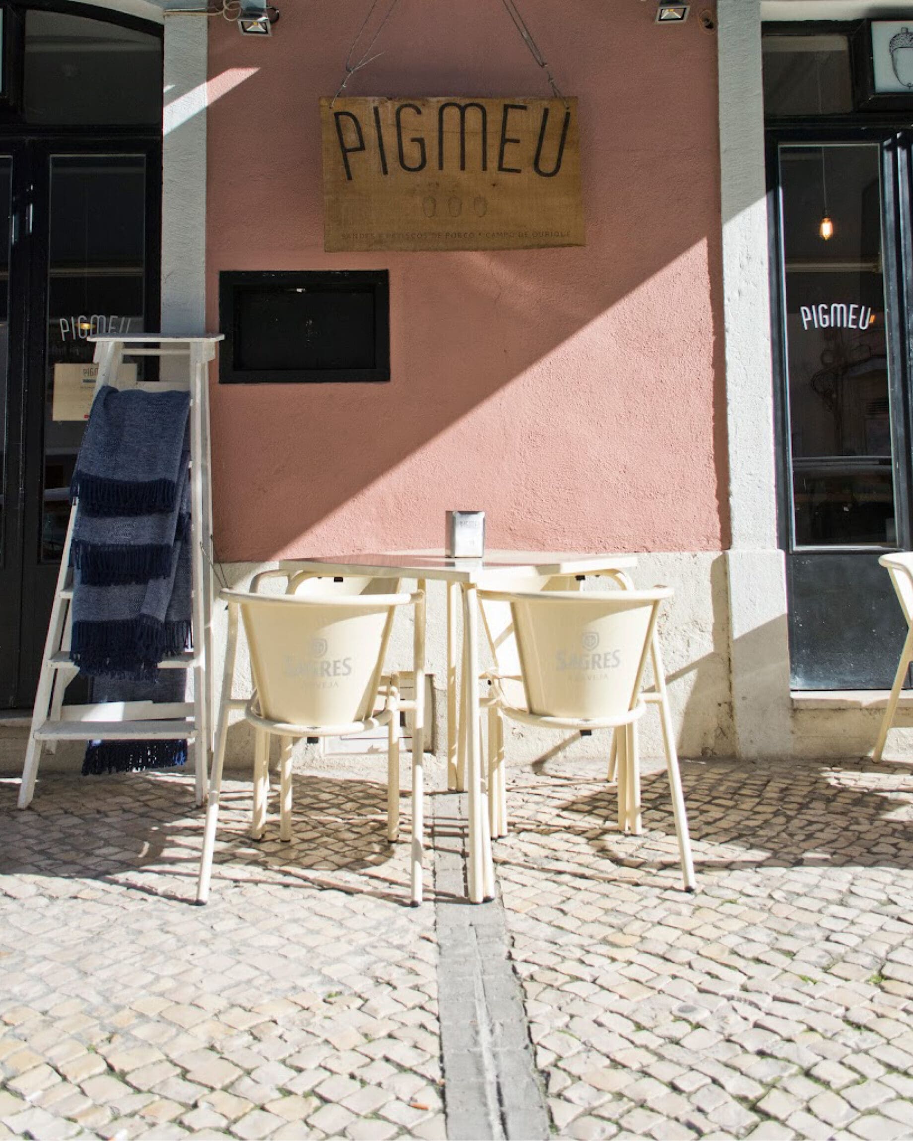 The pink exterior and outdoor seating at Pigmeu, Campo de Ourique