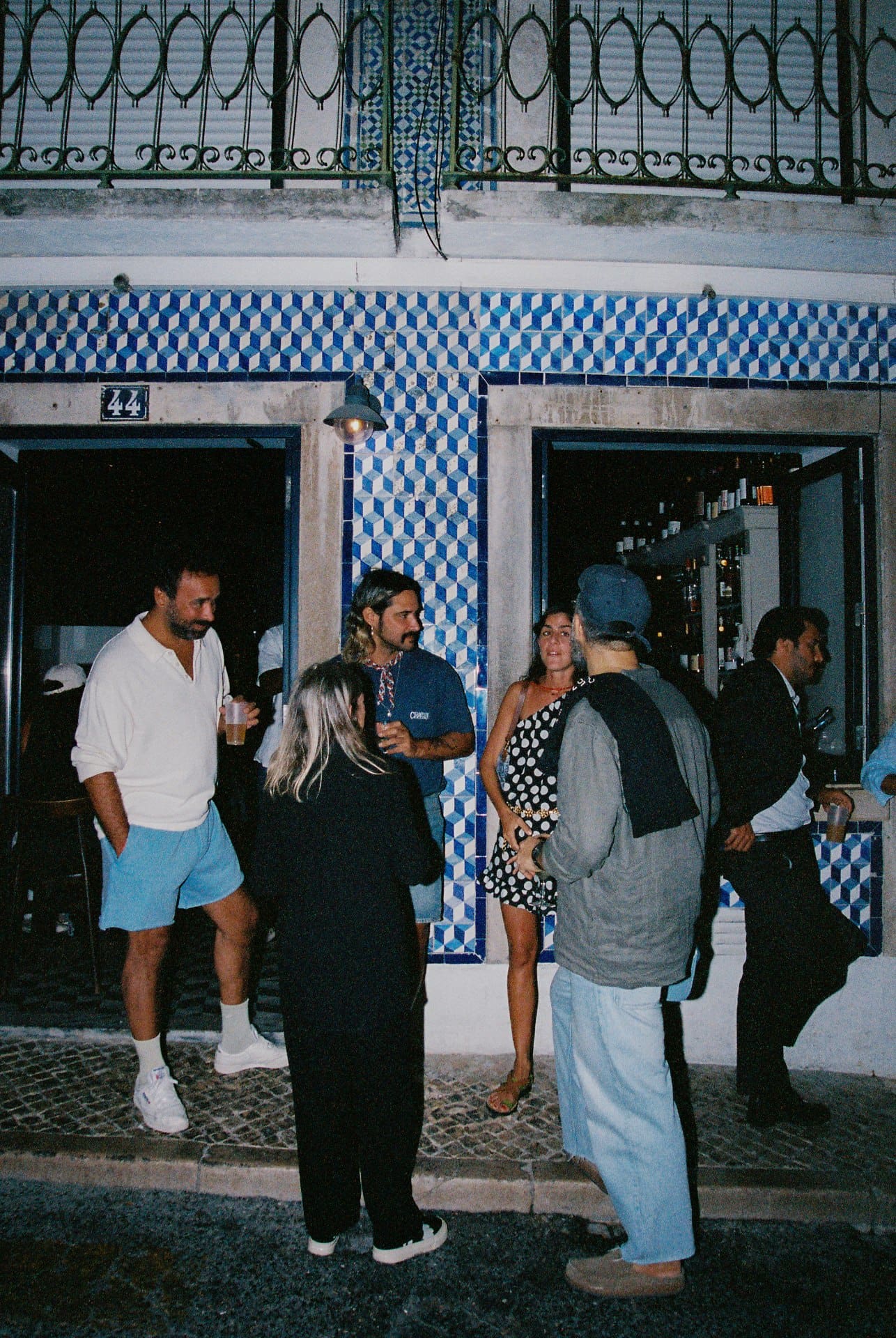 Casual guests outside Da Noi's blue exterior in Lisbon