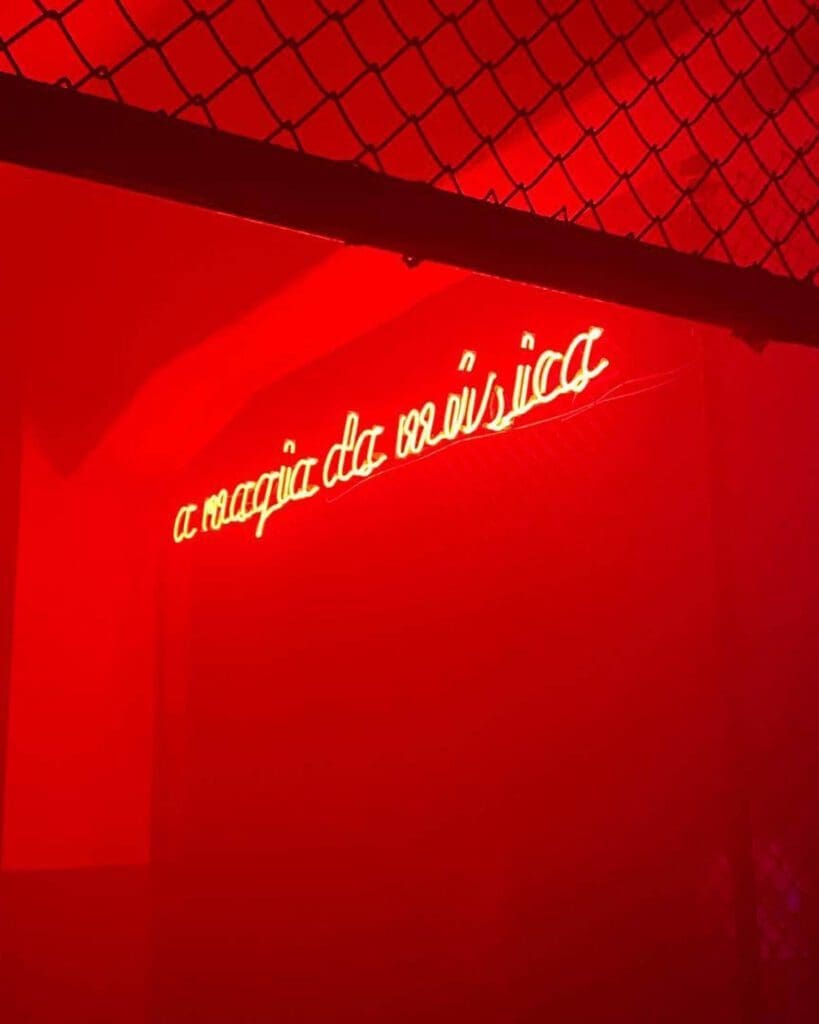 Where to watch live music in Lisbon | a neon sign on a red wall at Planeta Manas