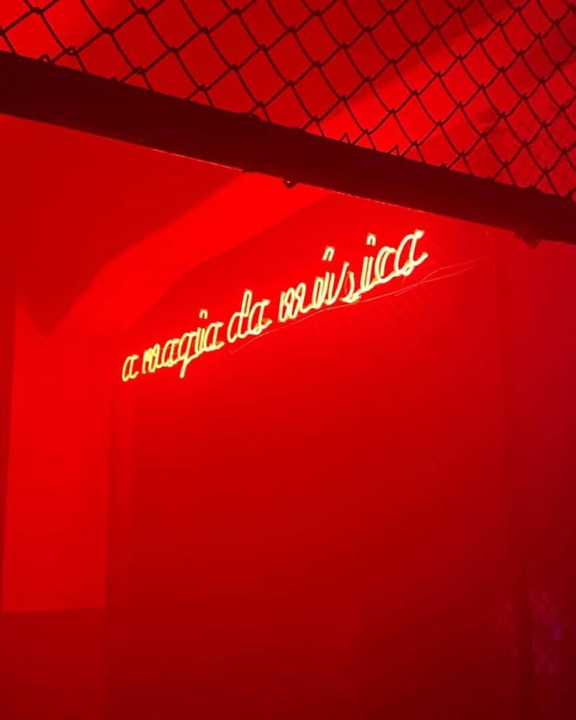 Where to watch live music in Lisbon | a neon sign on a red wall at Planeta Manas