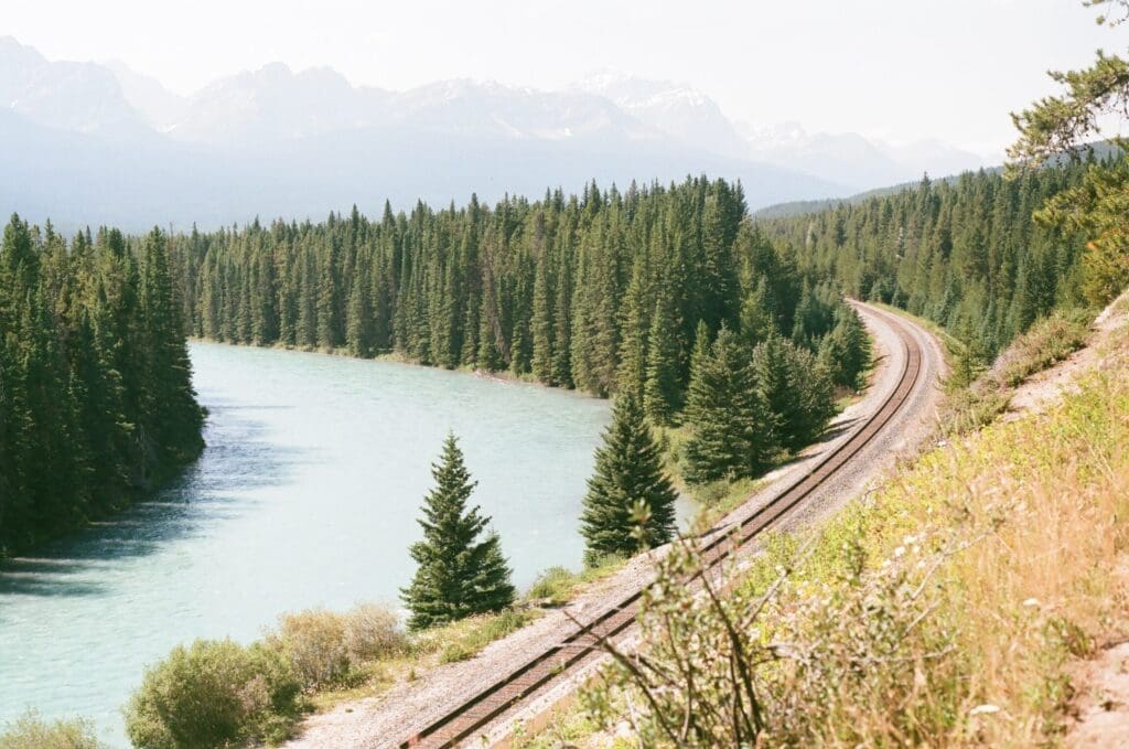 A train track in Alberta, Canada, with a lake in view