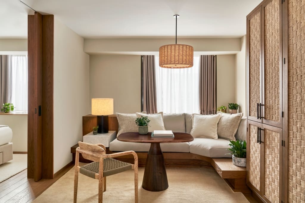 1 Hotel Mayfair | a living space with a rattan lamp and linen furnishings