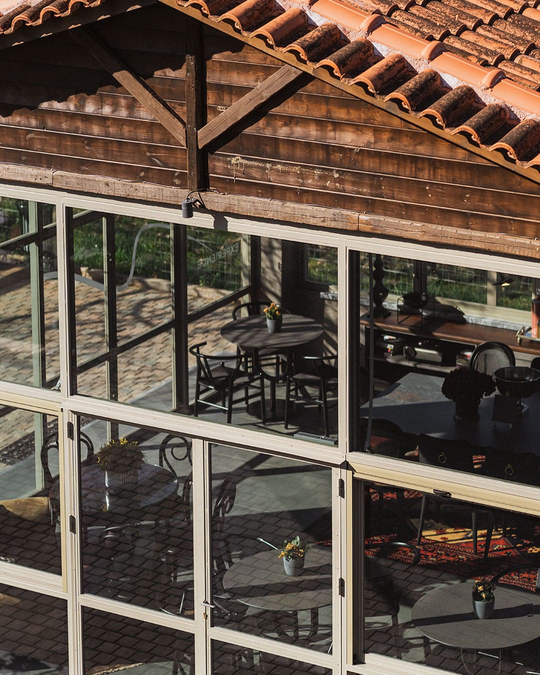 A building with glass windows and slanted roof shows an eating area within