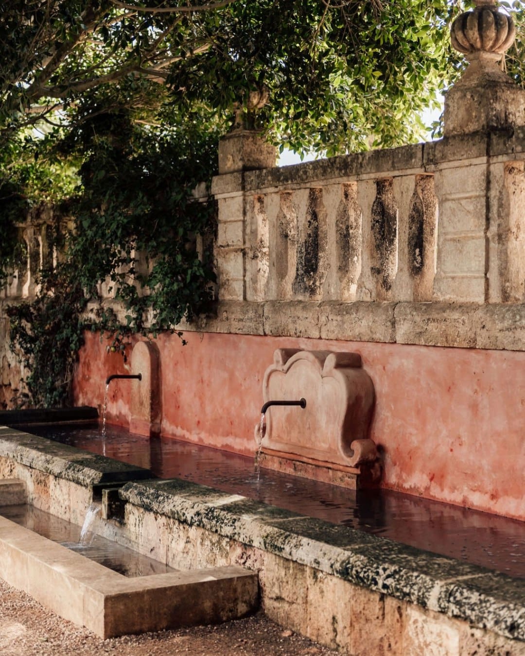 A pink wall with a tap at Son Vell Menorca