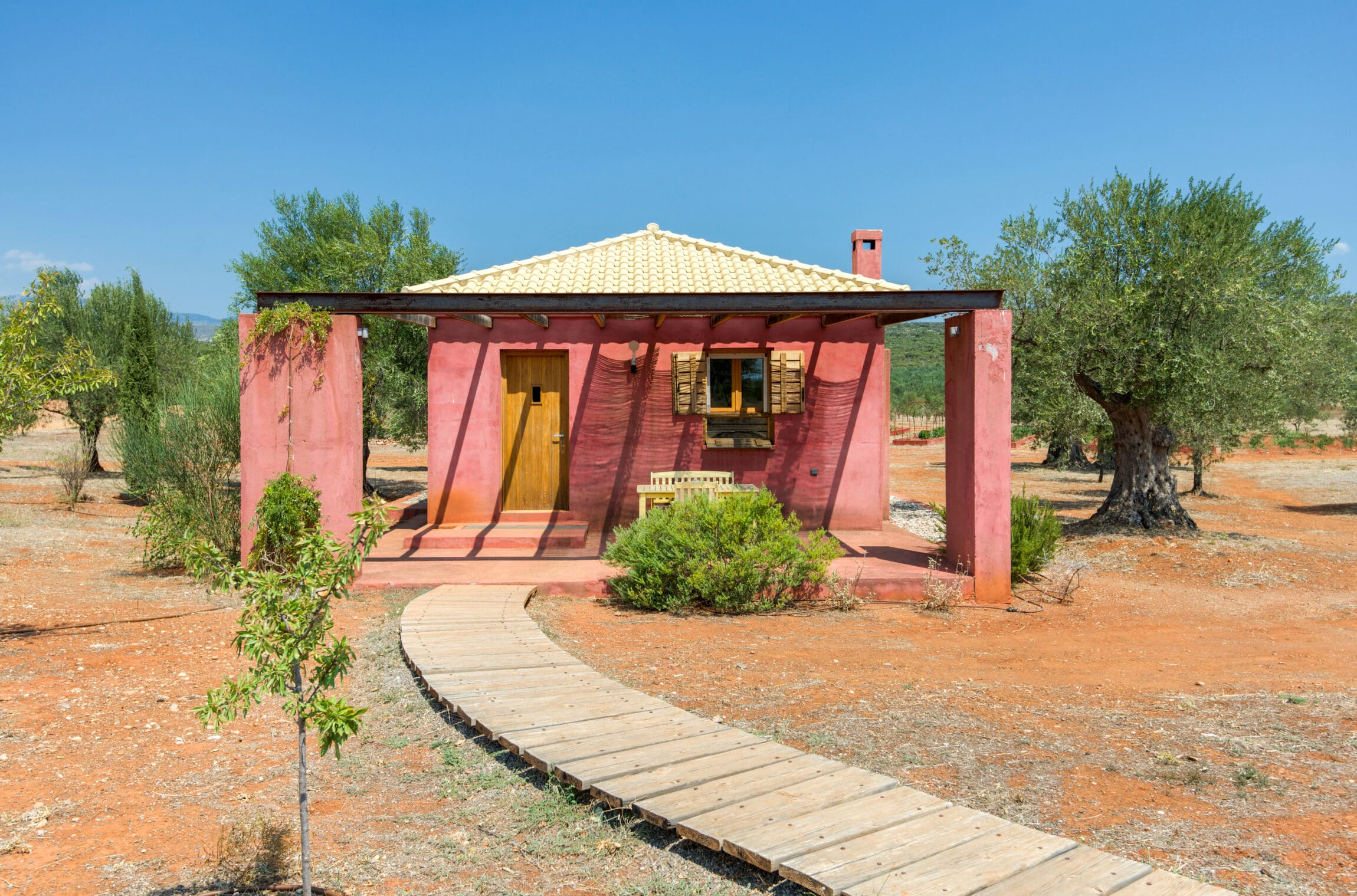 The rustic pink exterior of Eumelia Organic Agrotourism Farm, Greece