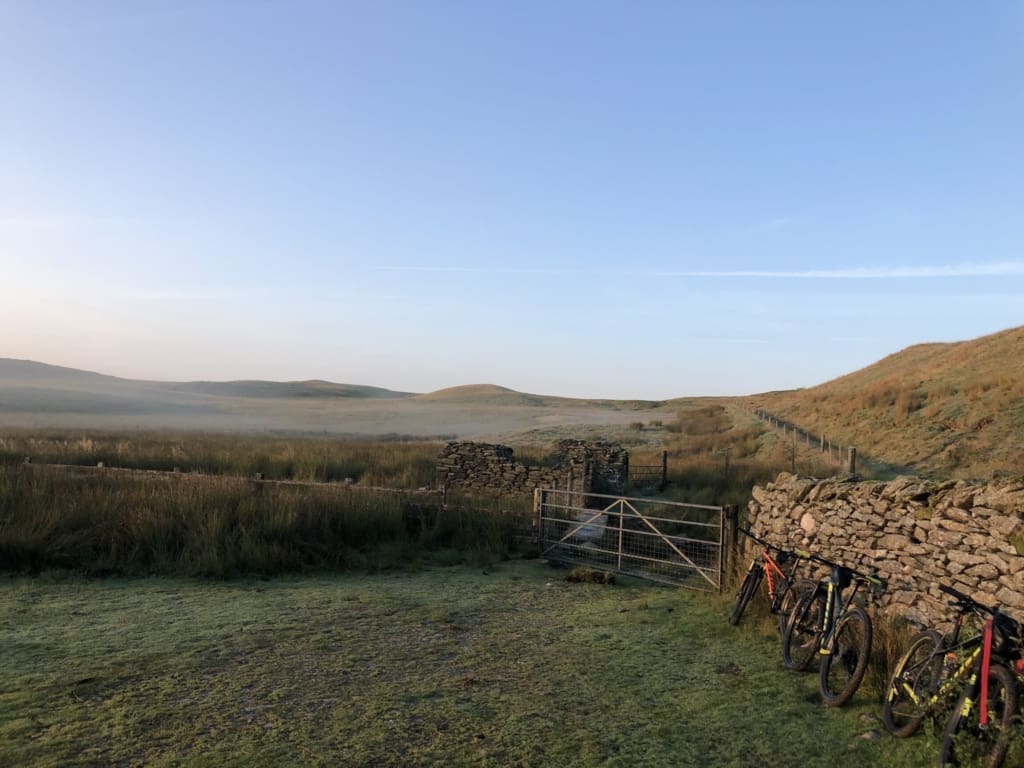 A complete guide to bikepacking in the UK | Bikes parked against a stone wall outside a bothy in Wales.