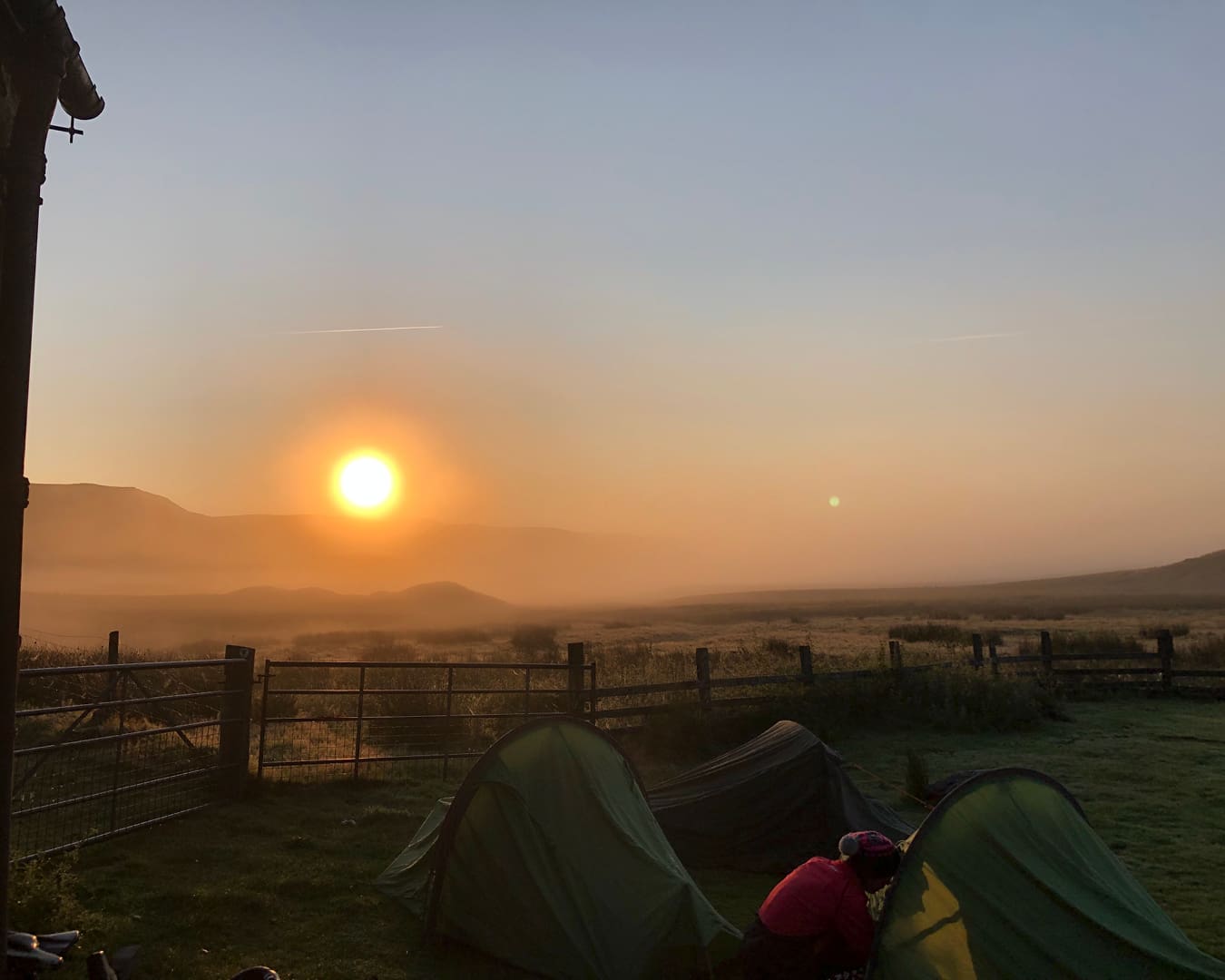 A complete guide to bikepacking in the UK | Sunrise over tents pitched outside a bothy in mid Wales.