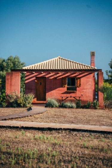 The rustic pink exterior of Eumelia Organic Agrotourism Farm, Greece