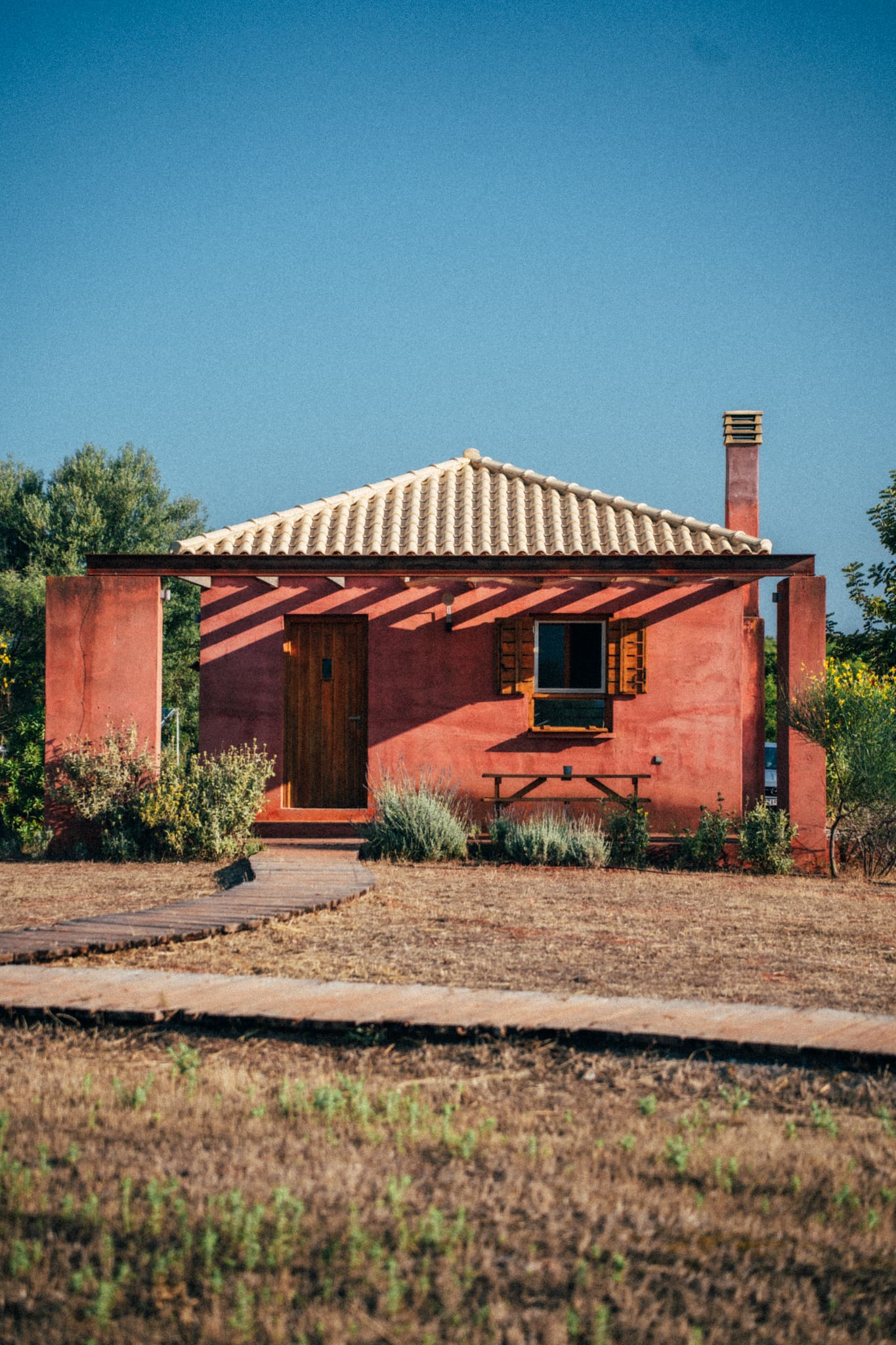 The best farm stays in Europe | The rustic pink exterior of Eumelia Organic Agrotourism Farm, Greece