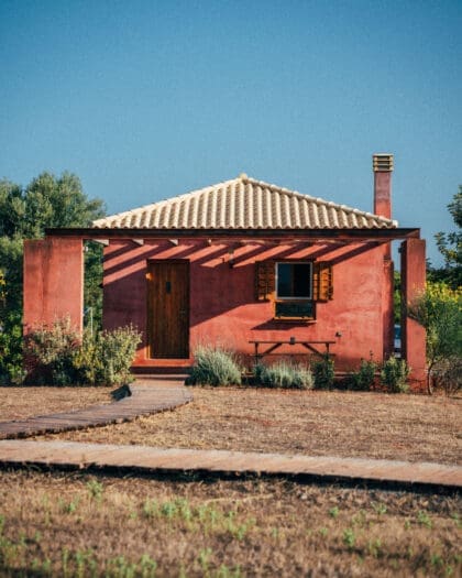 The rustic pink exterior of Eumelia Organic Agrotourism Farm, Greece