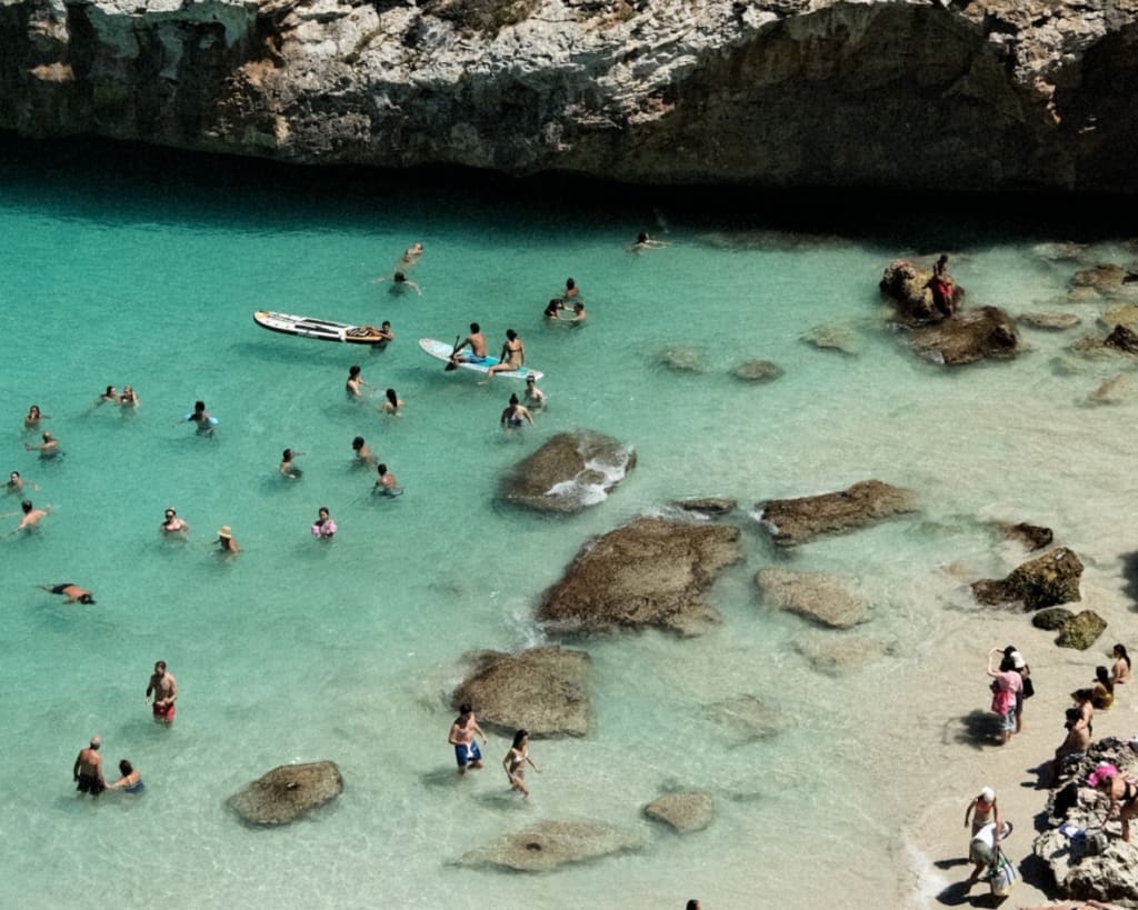 Overtourism in Europe | people splashing in the sea by the shoreline in Mallorca, Spain