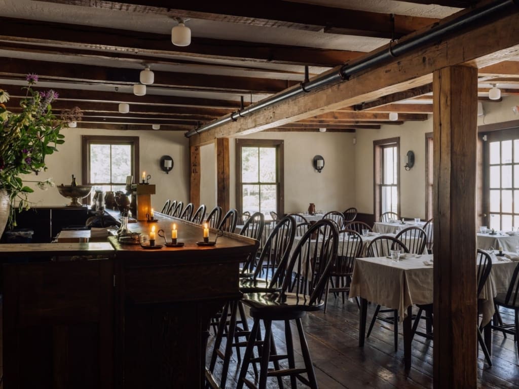 The best restaurants in Hudson NY | the atmospheric dining room at Stissing House with exposed wooden beams 
