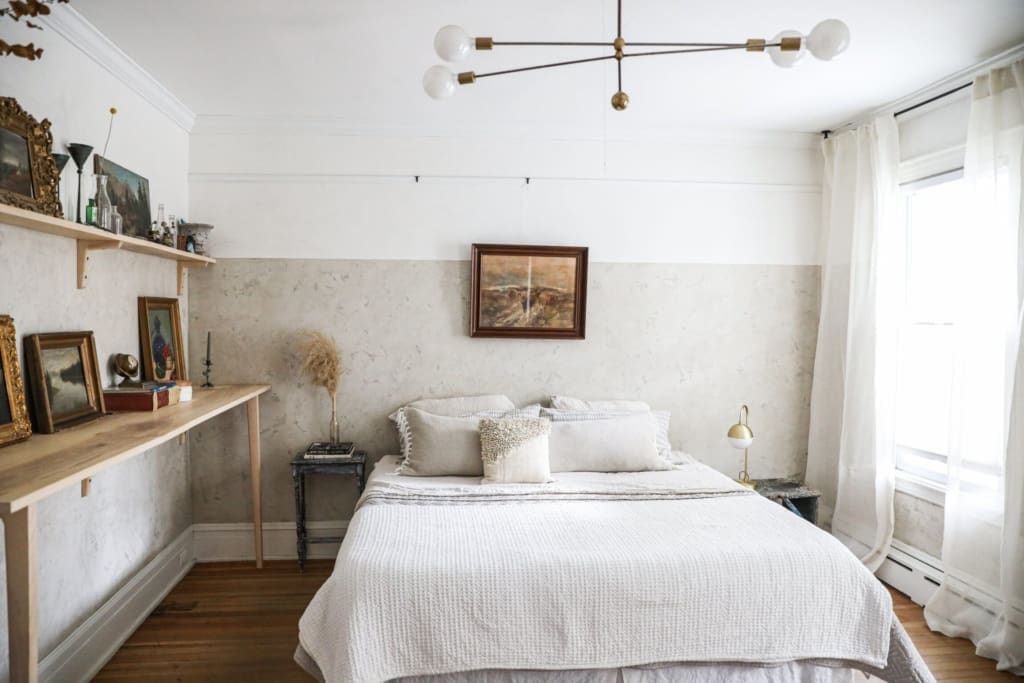 The best places to stay in Hudson | a stylish white bedroom with curated art on a shelf at This Old Hudson 