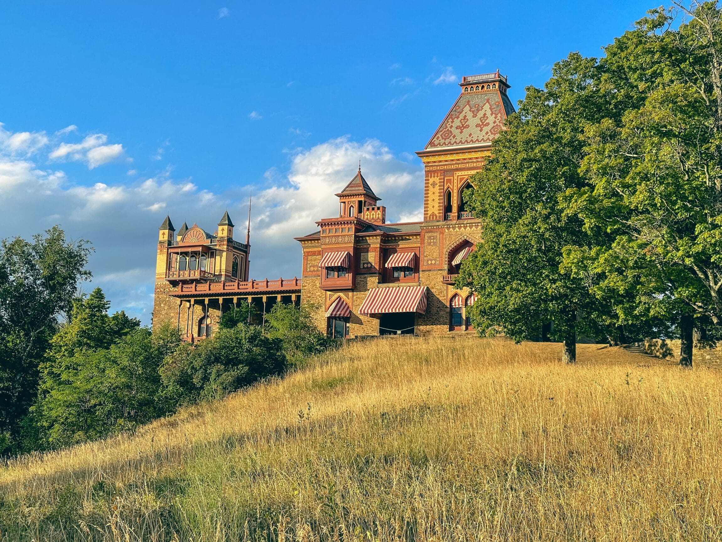The best things to do in Hudson | Olana State Historic Site atop a hill beneath a blue sky, photography by Matt Arnold