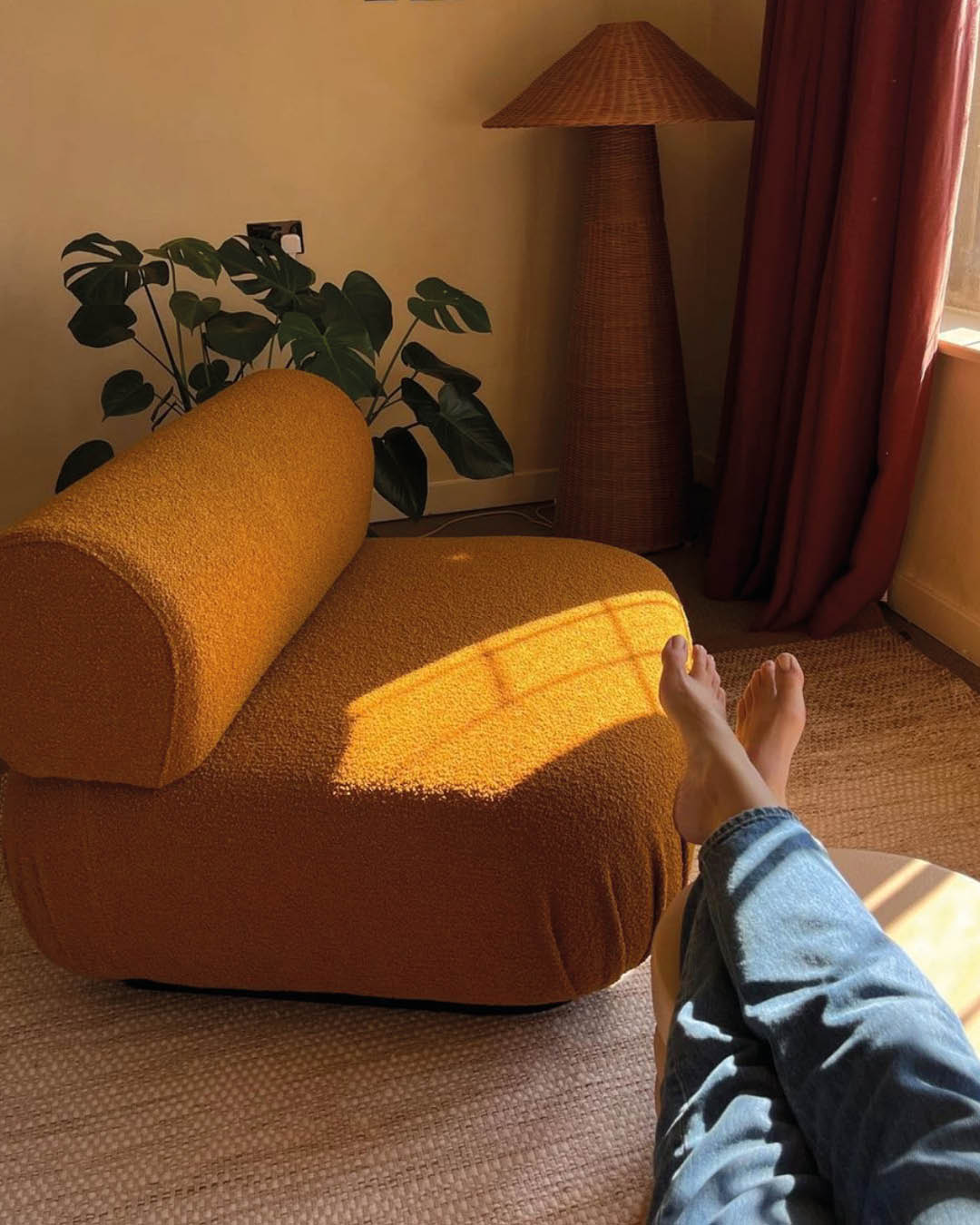 Dappled light on a mustard yellow chair, with feet in view at Birch Selson, photography by Alice Tate