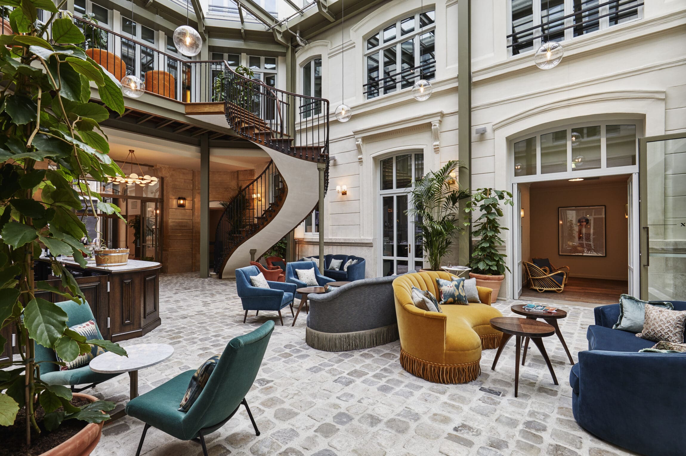 The outdoor courtyard at The Hoxton, Paris, with velvet seating