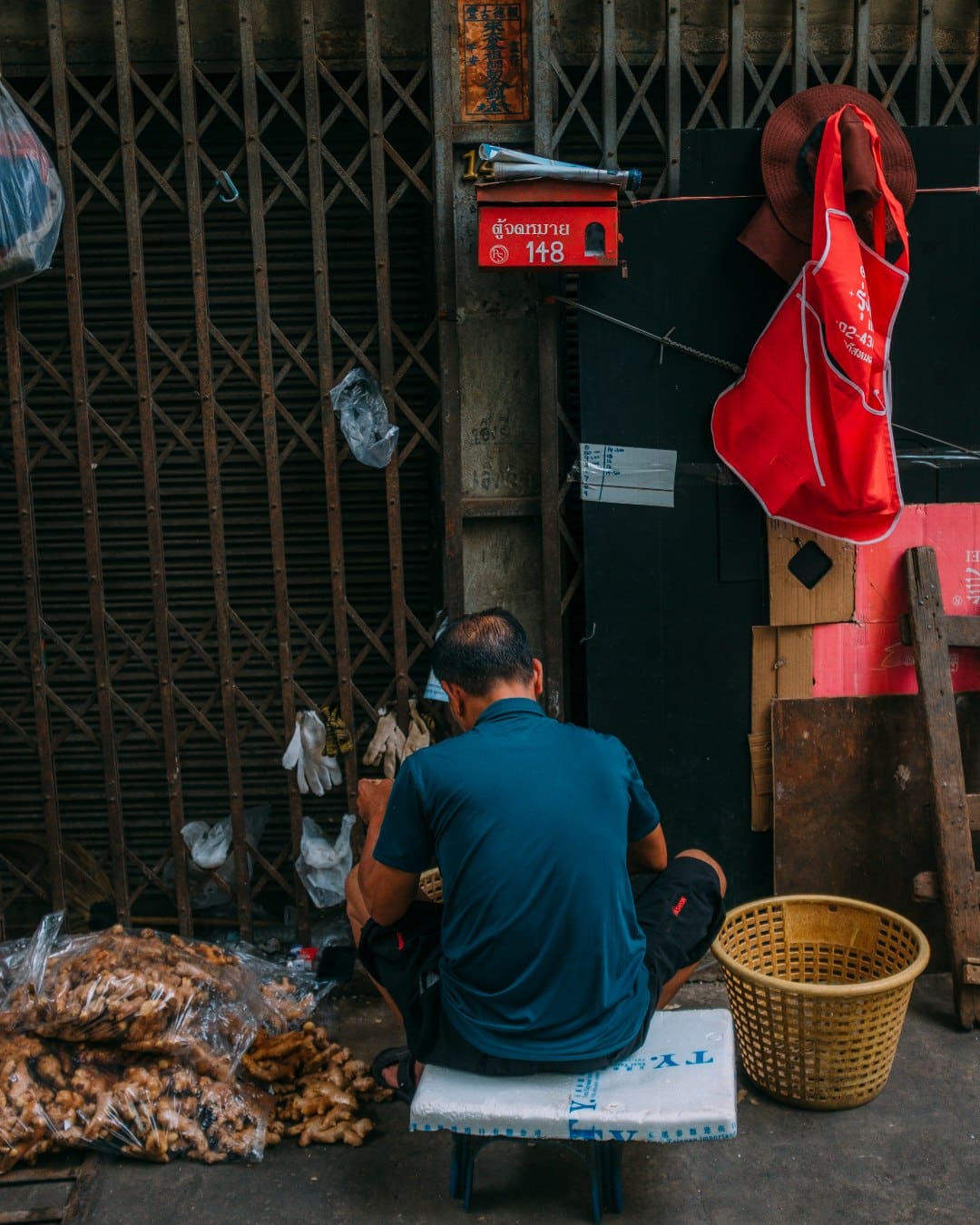 A man roadside at a Bangkok market. Photography by Adam Birkan