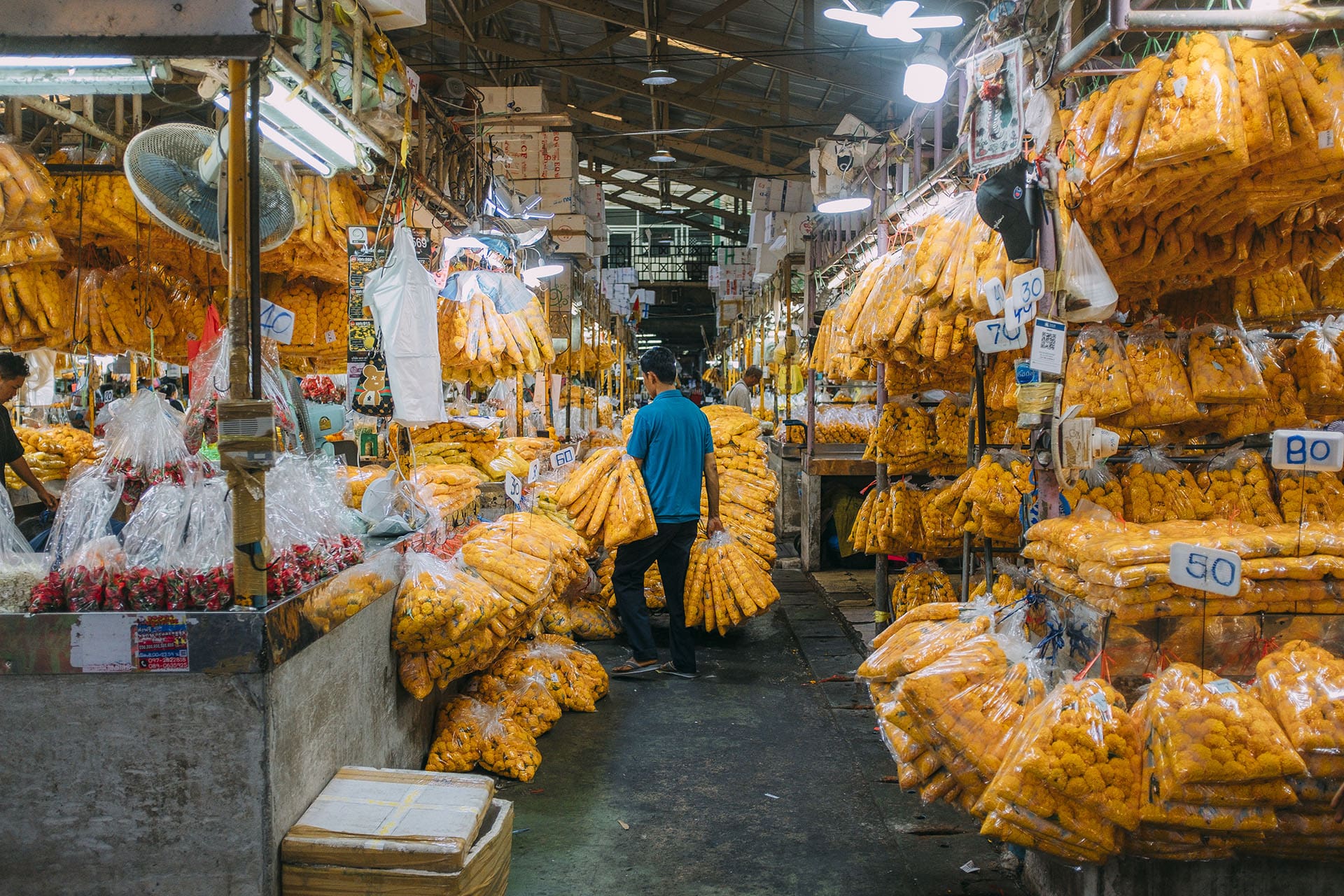 A man amongst bags of flowers at A man on a bike at Pak Khlong Talat (Flower Market)