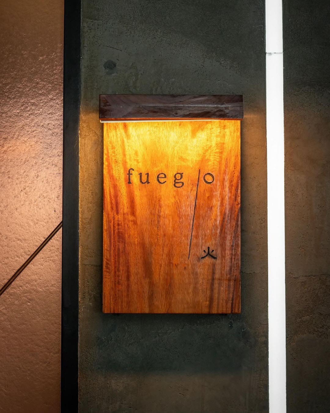 The best restaurants and bars in Bangkok's Thonglor | A wooden sign for the restaurant Fuego in Bangkok.