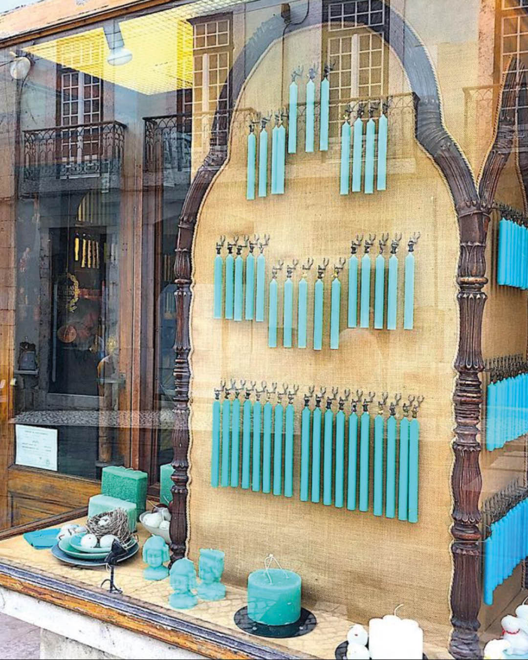 Blue votive candles hanging in a window display at Caza das Vellas Loreto.