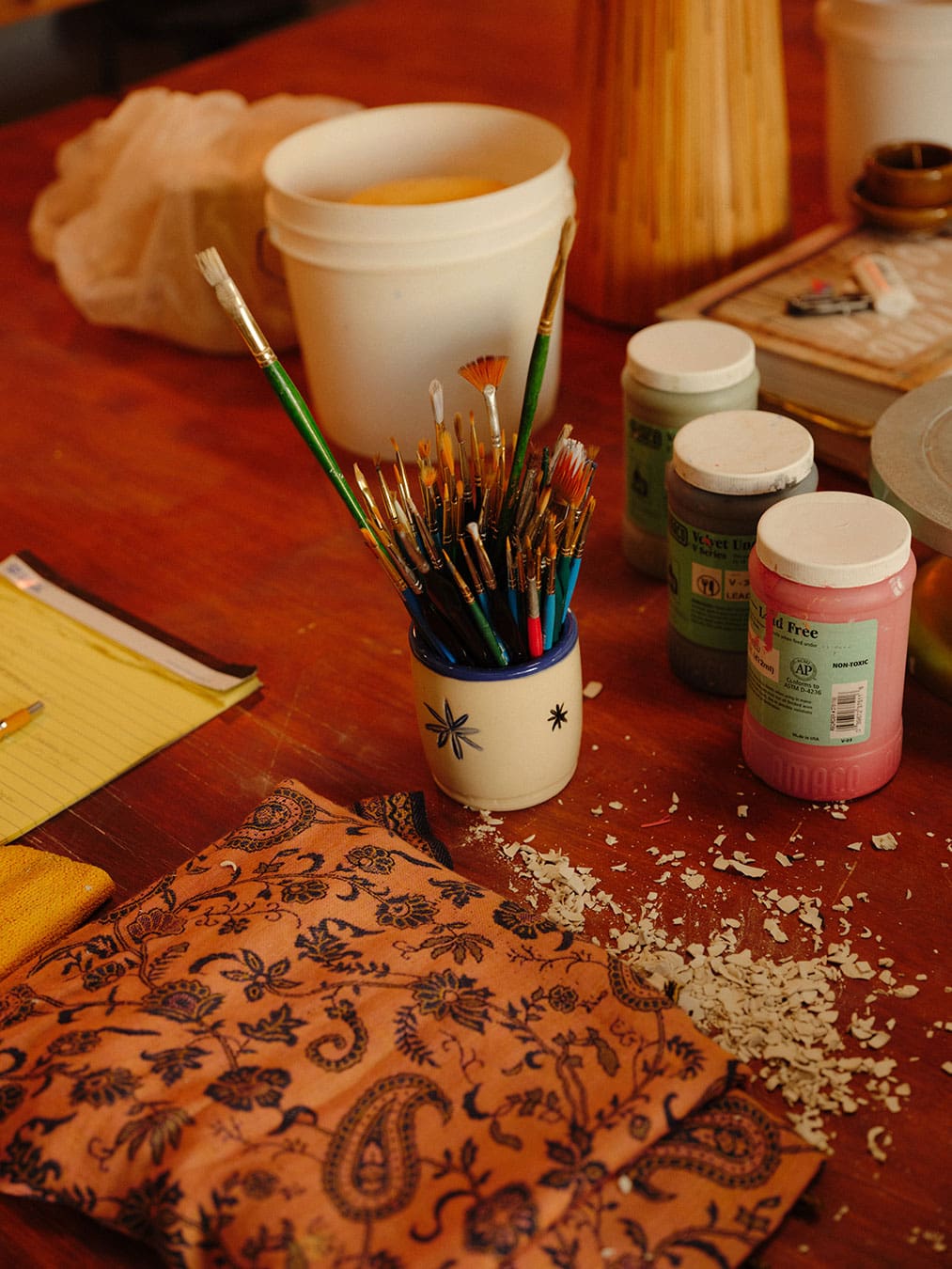 How Did I Get Here with Daniel Dooreck of Danny D's Mud Shop | A detail of paint brushes on a workbench in the studio.