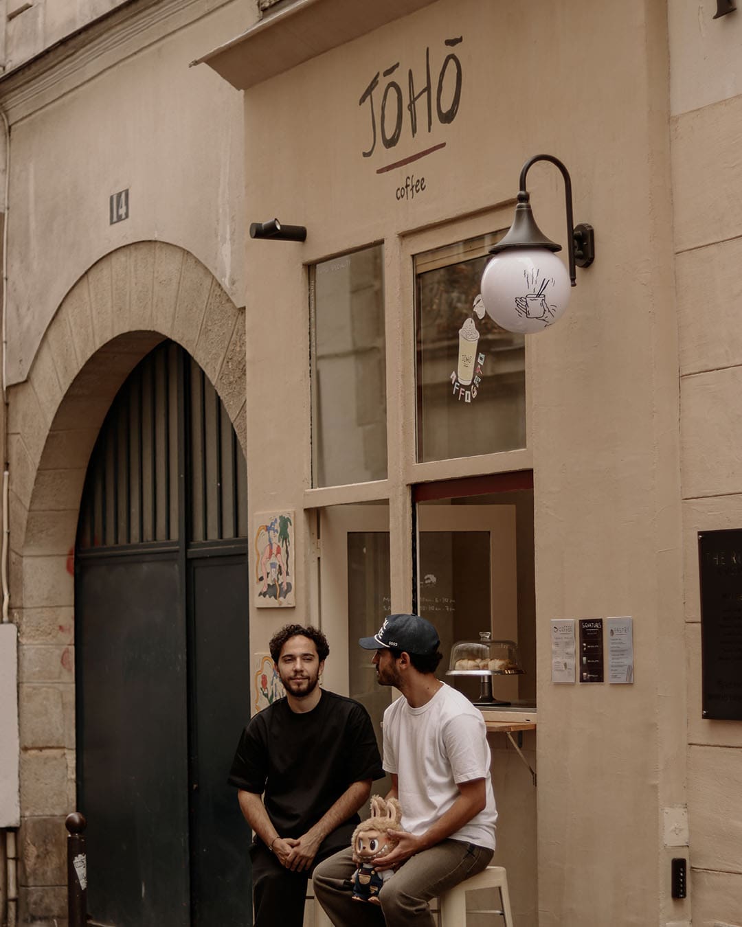 Two people drinking coffee outside Jōhō in Paris