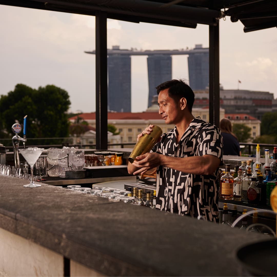 A bartender shaking a cocktail at Southbridge rooftop bar, Singapore