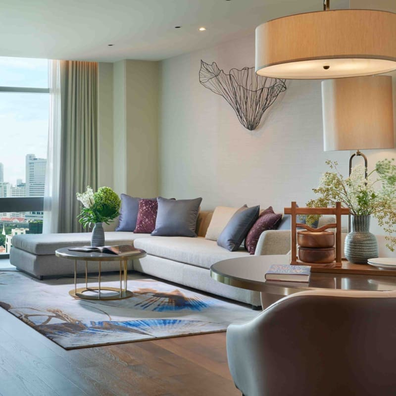 view of room toward window showing l shaped sofa and luxury furnishings in a one bedroom suite