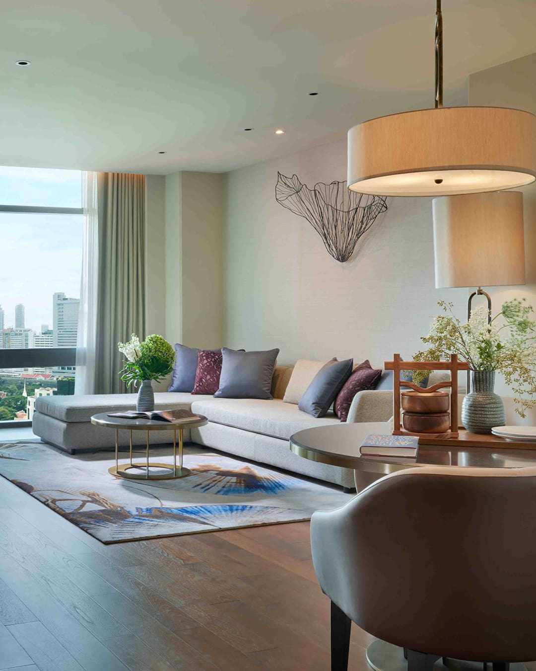 Lounge area and window view of city in a suite at Chatrium Grand Bangkok