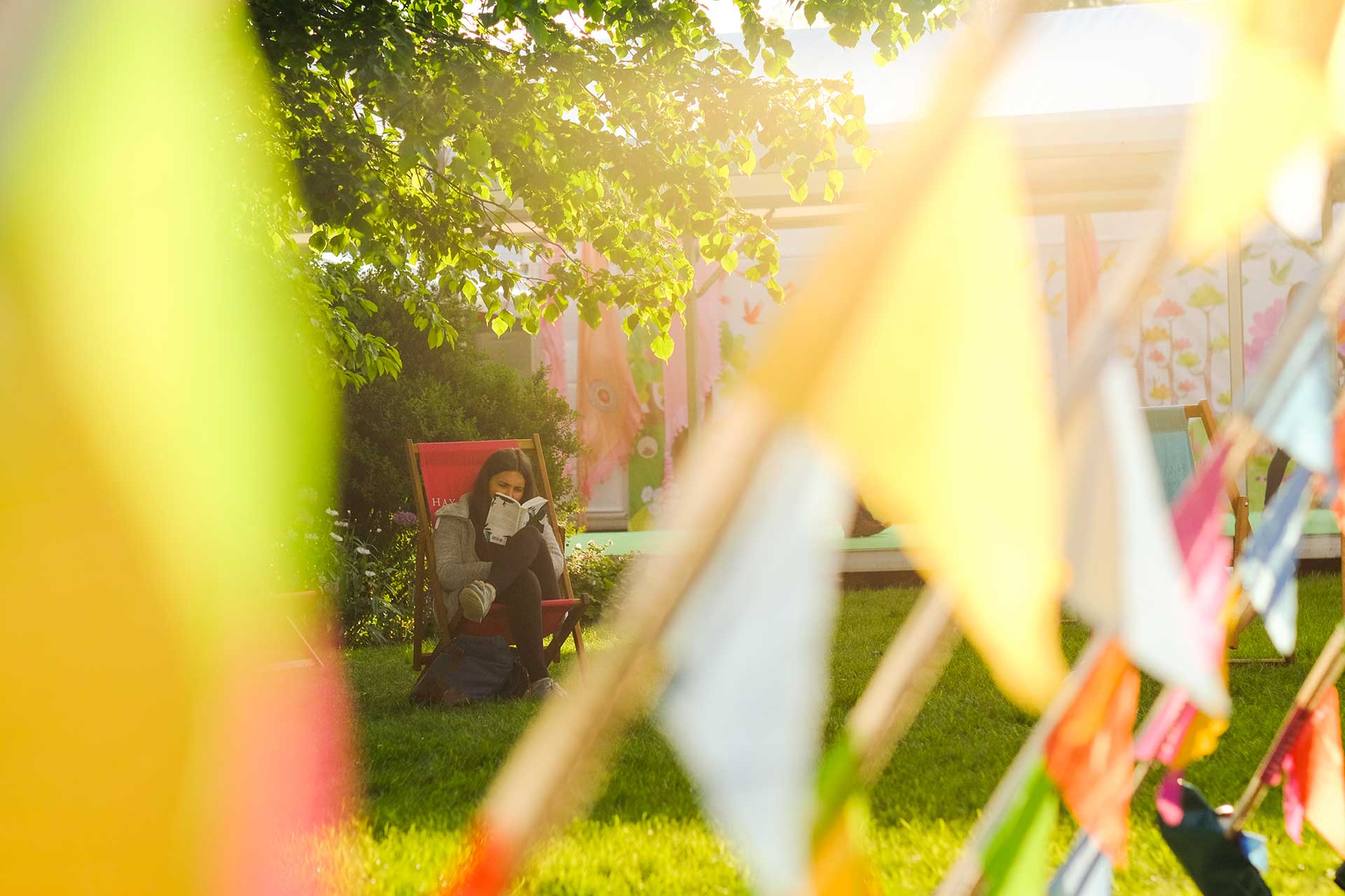 Attendee at Hay Festival reads book in a deckchair