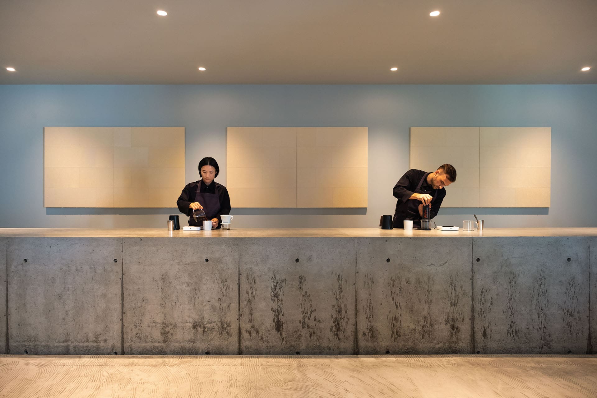 Two people working in Ogawa Coffee Laboratory putting together coffee for customers in a futuristic looking space