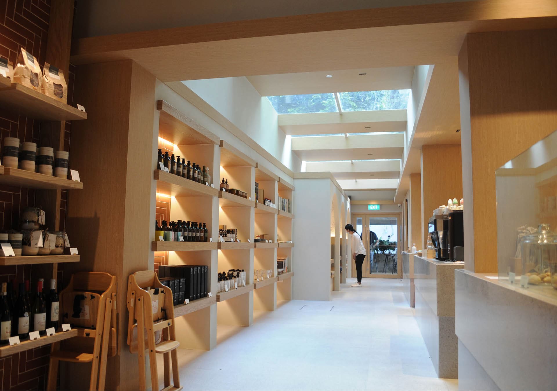 Merchandise lines wooden shelves opposite the coffee counter at Plain Vanilla, Singapore.