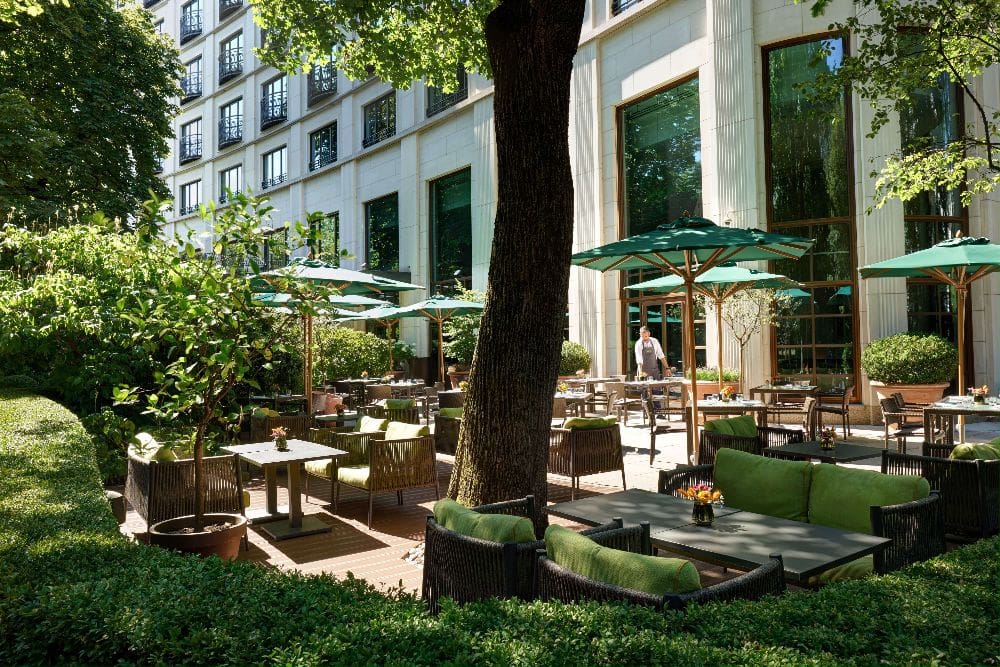 Green parasols line the outdoor terrace at The Charles Hotel in Munich