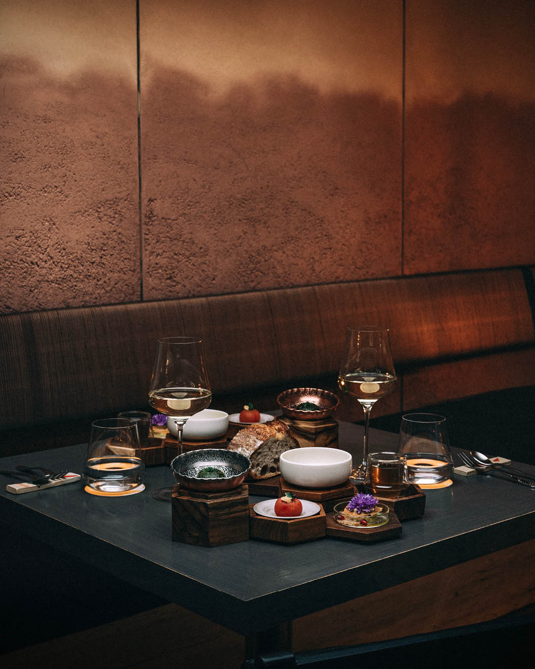 A selection of dishes served on a black table at Nouri, Singapore.