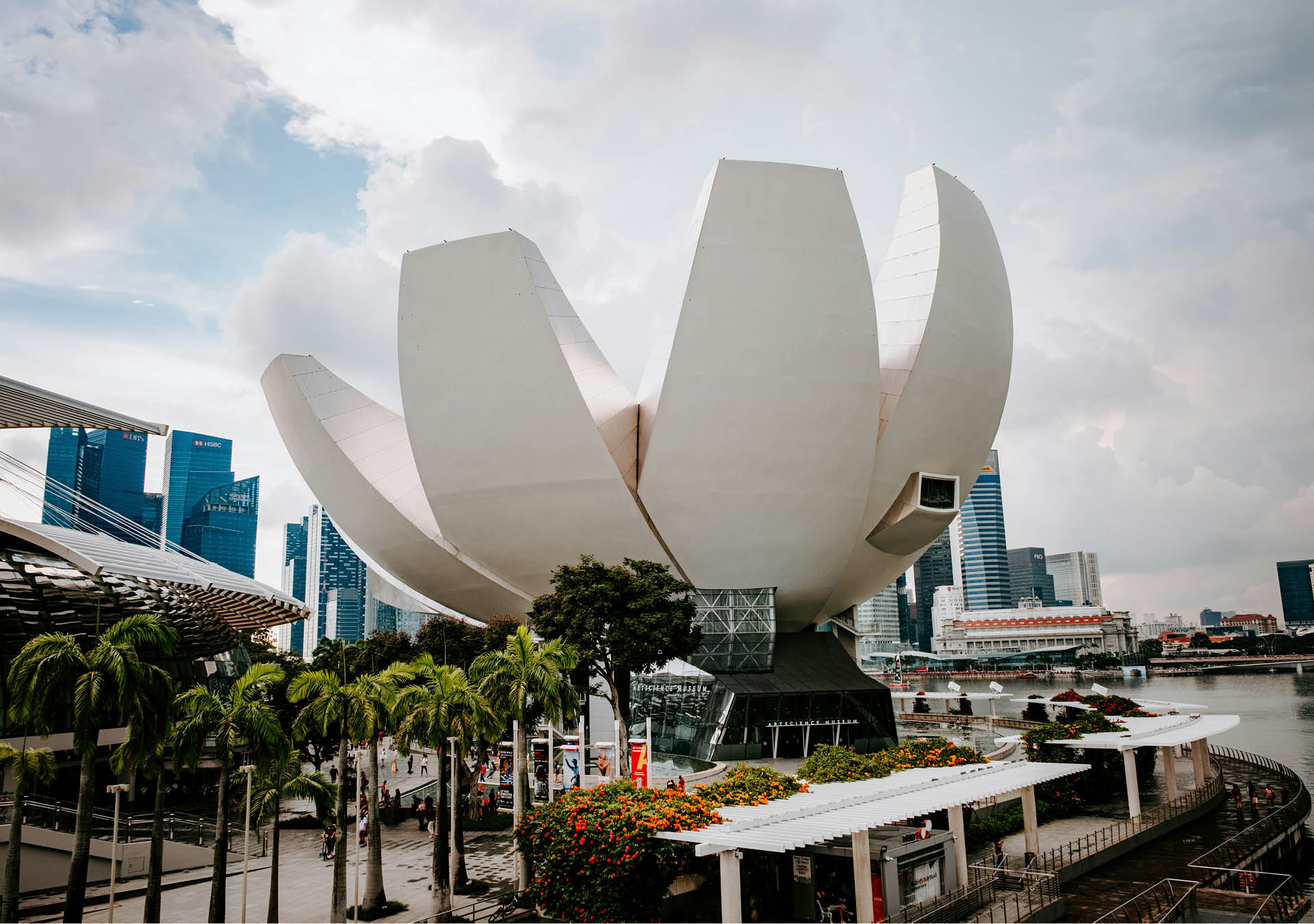 The facade of ArtScience Museum in Singapore against a blue and white sky.