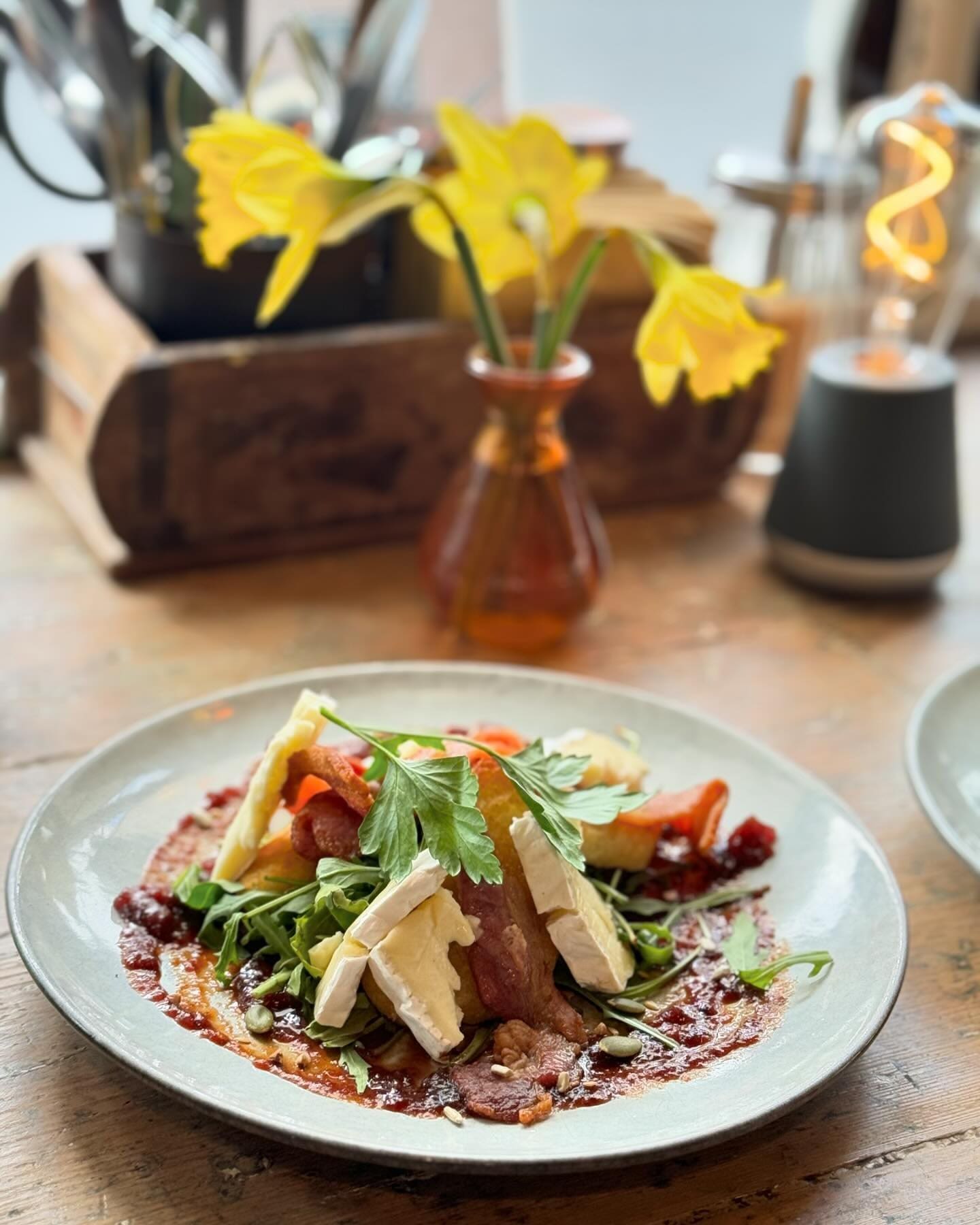 Food and flowers line the table at Cosy Cafe, Hay-on-Wye