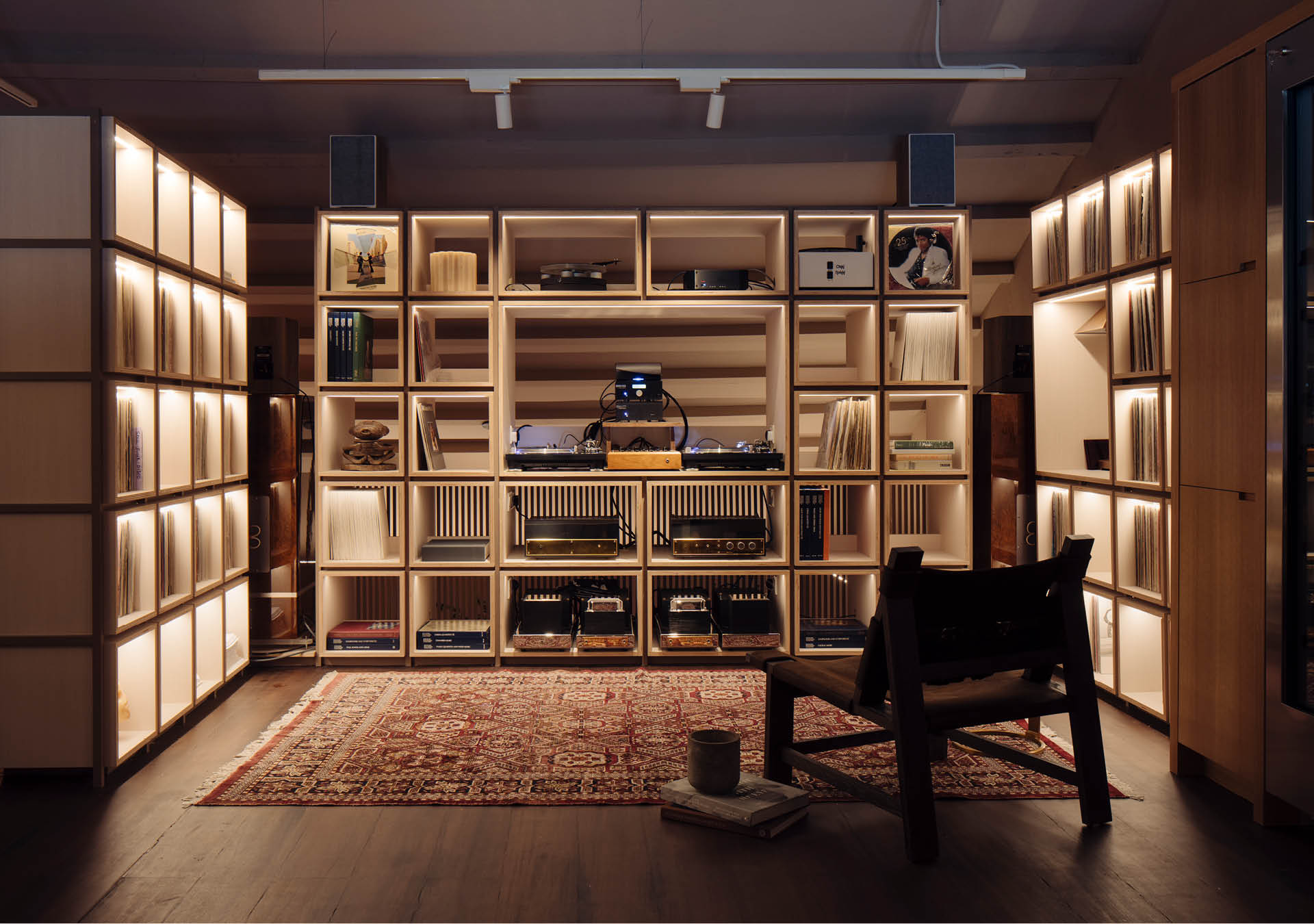The listening room at Appetite in Singapore, where a lounge chair and rug face three shelving units.