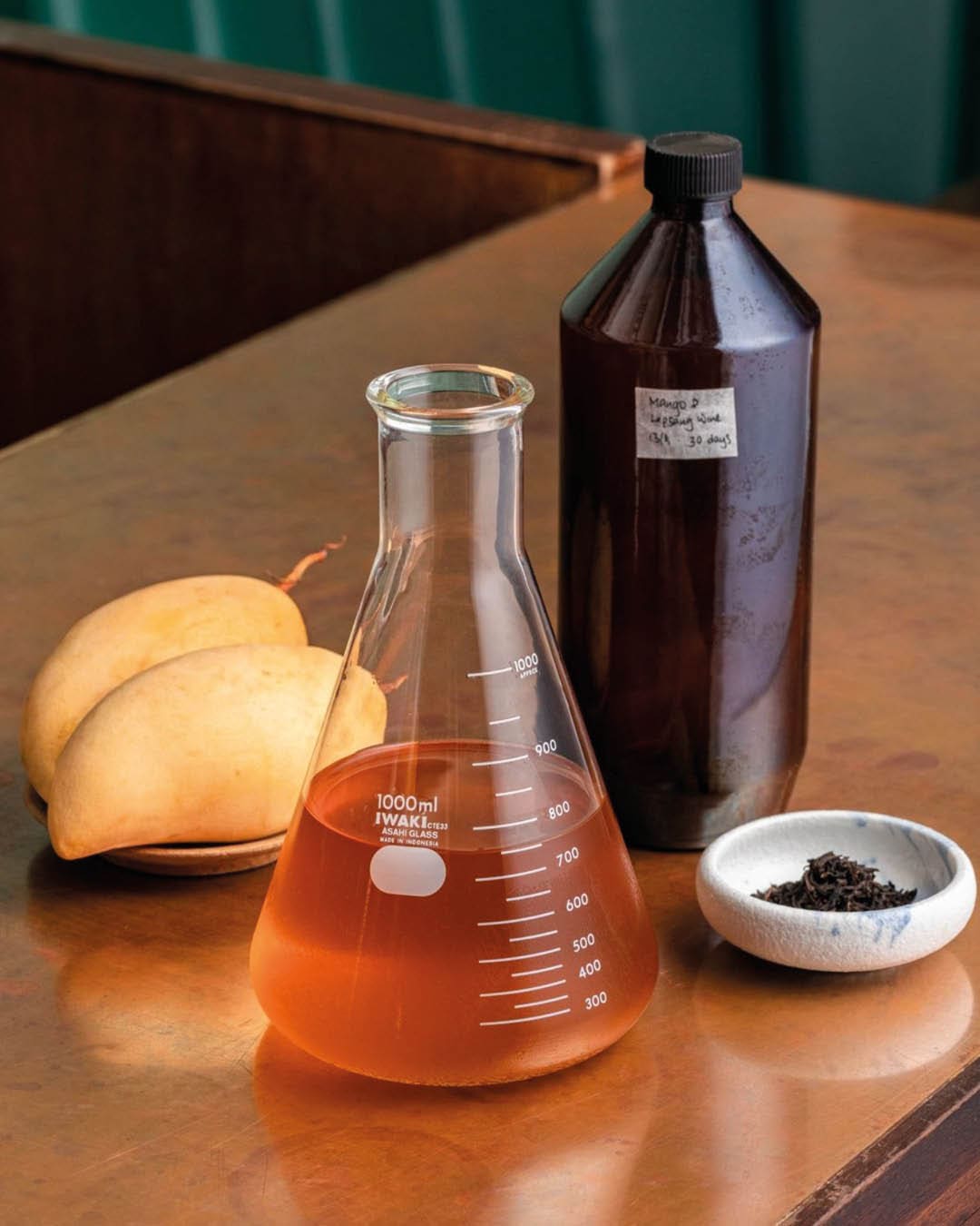 Mango lapsing wine served in a lab beaker at Native cocktail bar in Singapore.