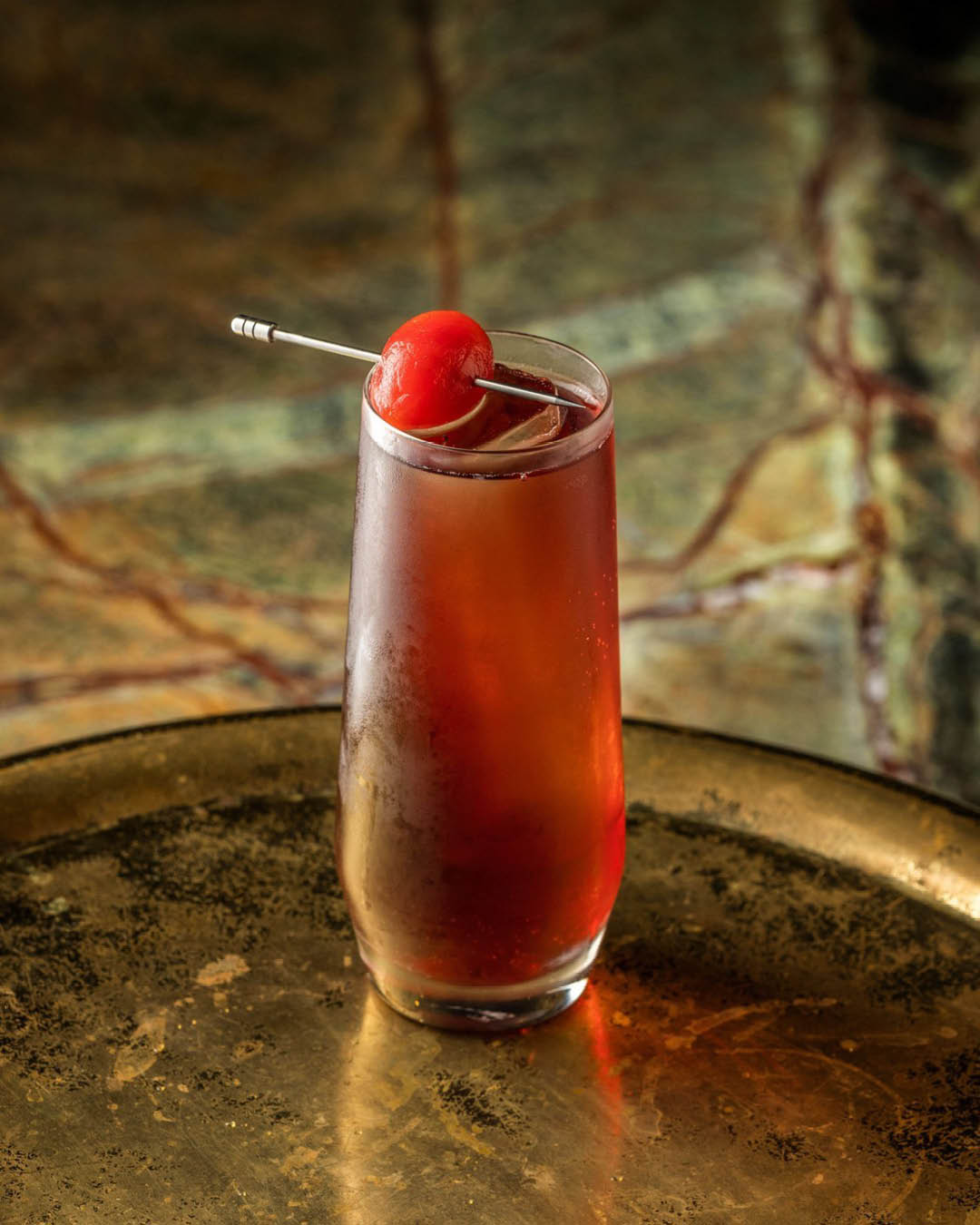 A red cocktail made with Hendrick's Gin, clarified tomato juice, port, plum syrup and plum bitters and served at Manhattan cocktail bar in Singapore.
