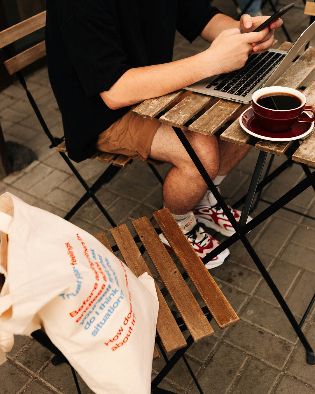 Man sits at cafe with laptop and coffee on table