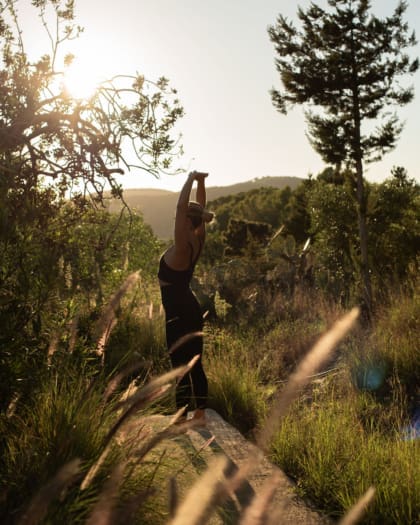 Fitness & Wellness Retreats | Wylder guest doing yoga stretches at sundown