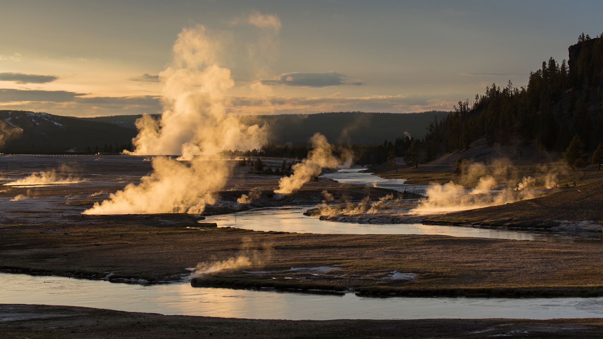 Clouds of steam rise from volcanic hot springs at Yellowstone National Park.