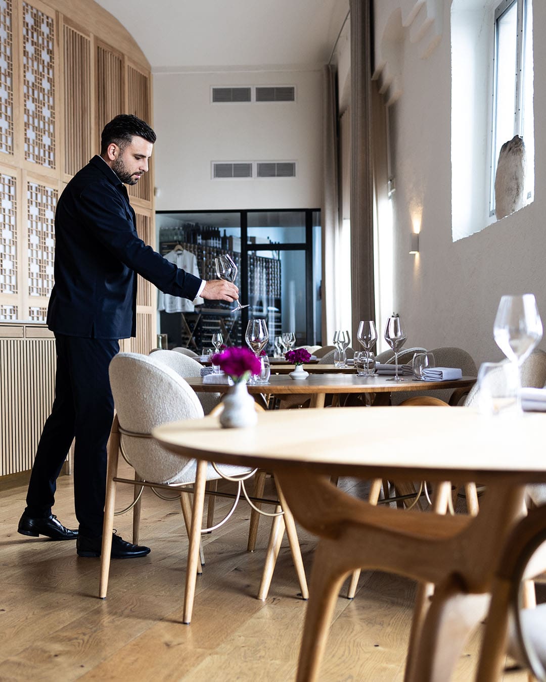 Sommelier arranges glasses at modern airy restaurant in Copenhagen