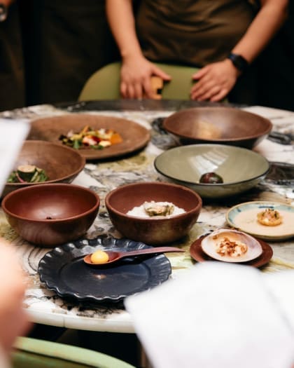 A gourmet dining table featuring an elegantly presented dishes in various bowls and plates.