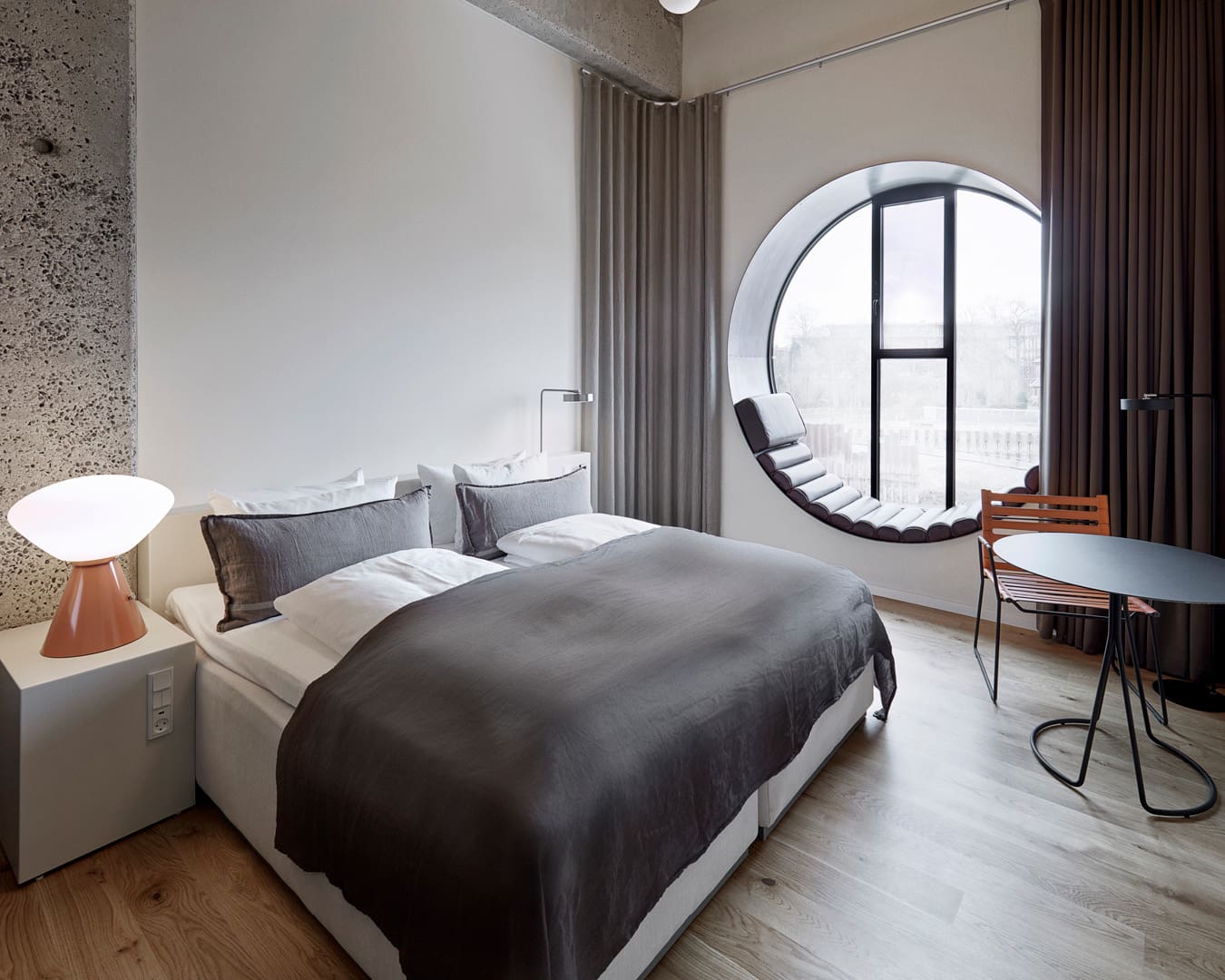 A circular window topped with a cushioned seat at Hotel Ottilia in Vesterbro