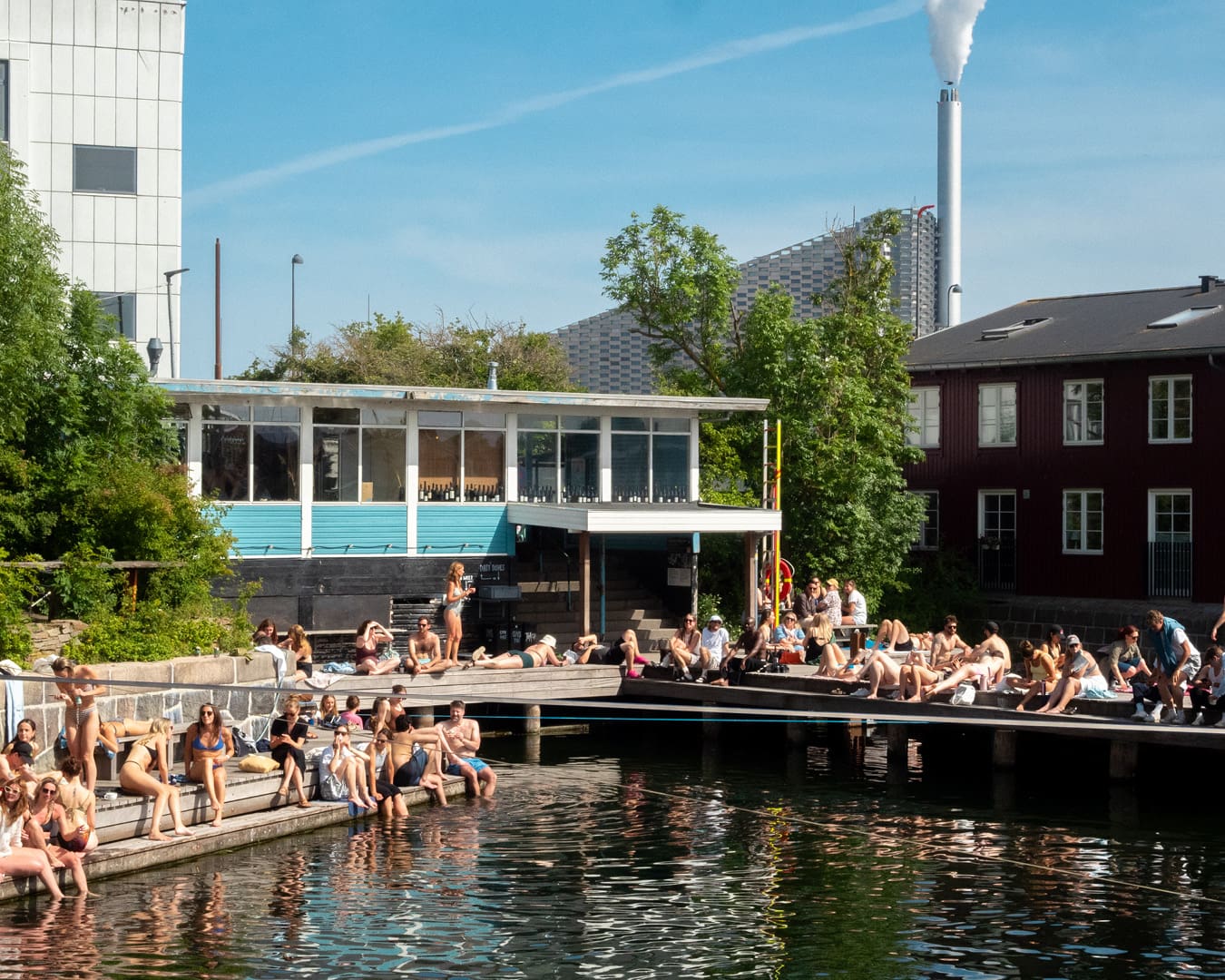 Locals gather on the edge of the water at La Banchina bar in Holmen, Copenhagen