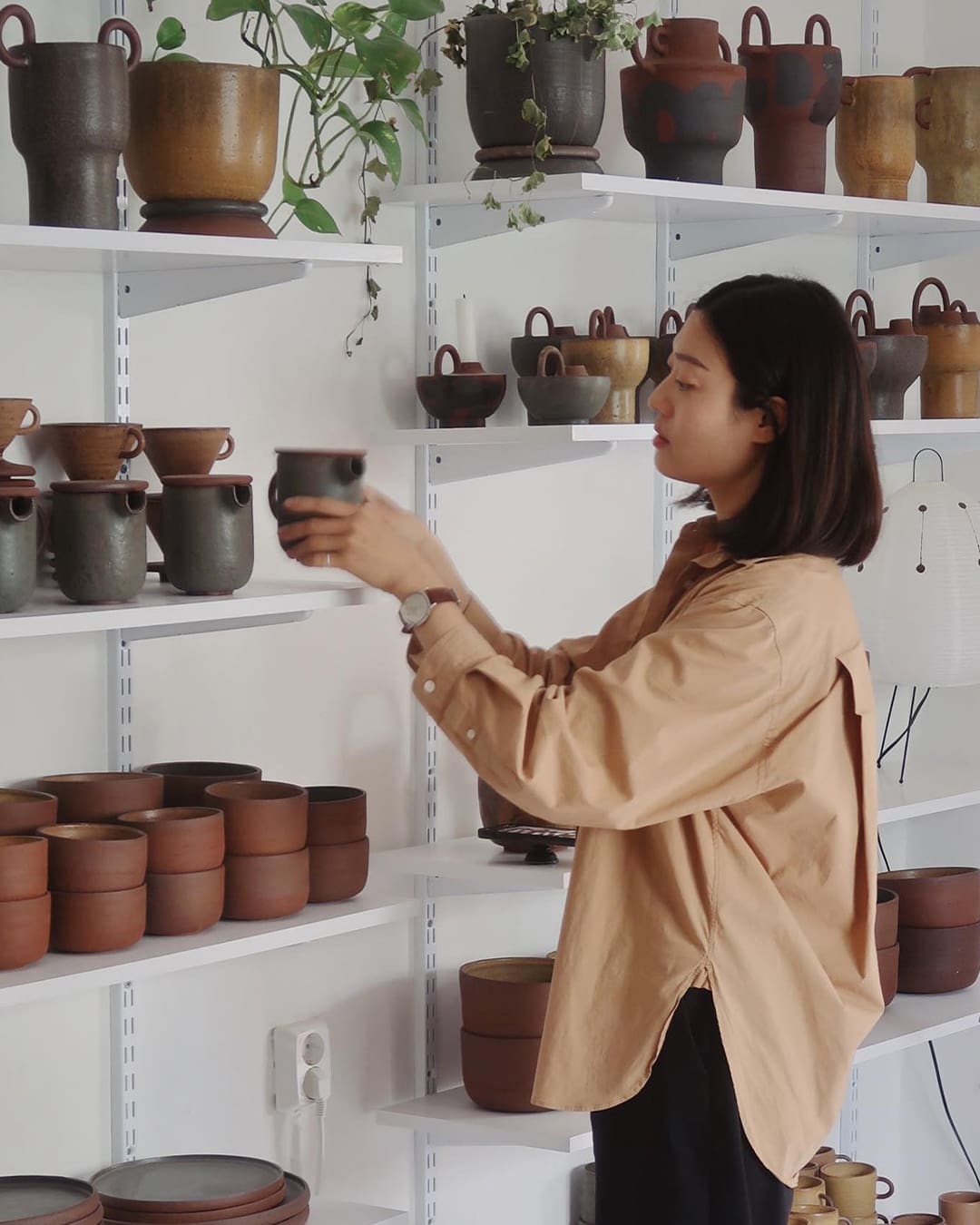 Shopper examines pottery at General Furnishings & Co