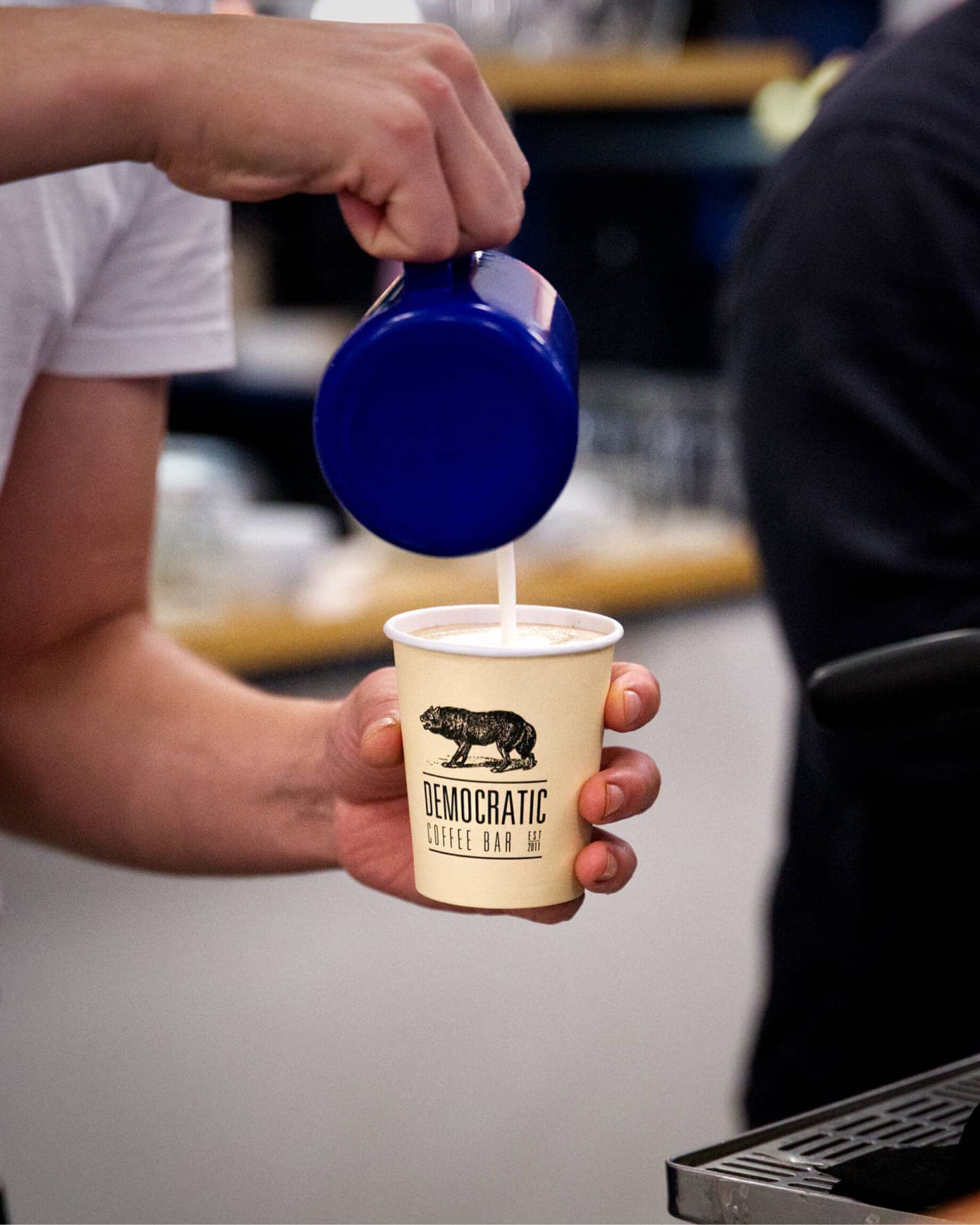 A barista pours a flat white at Democratic Coffee in Copenhagen.